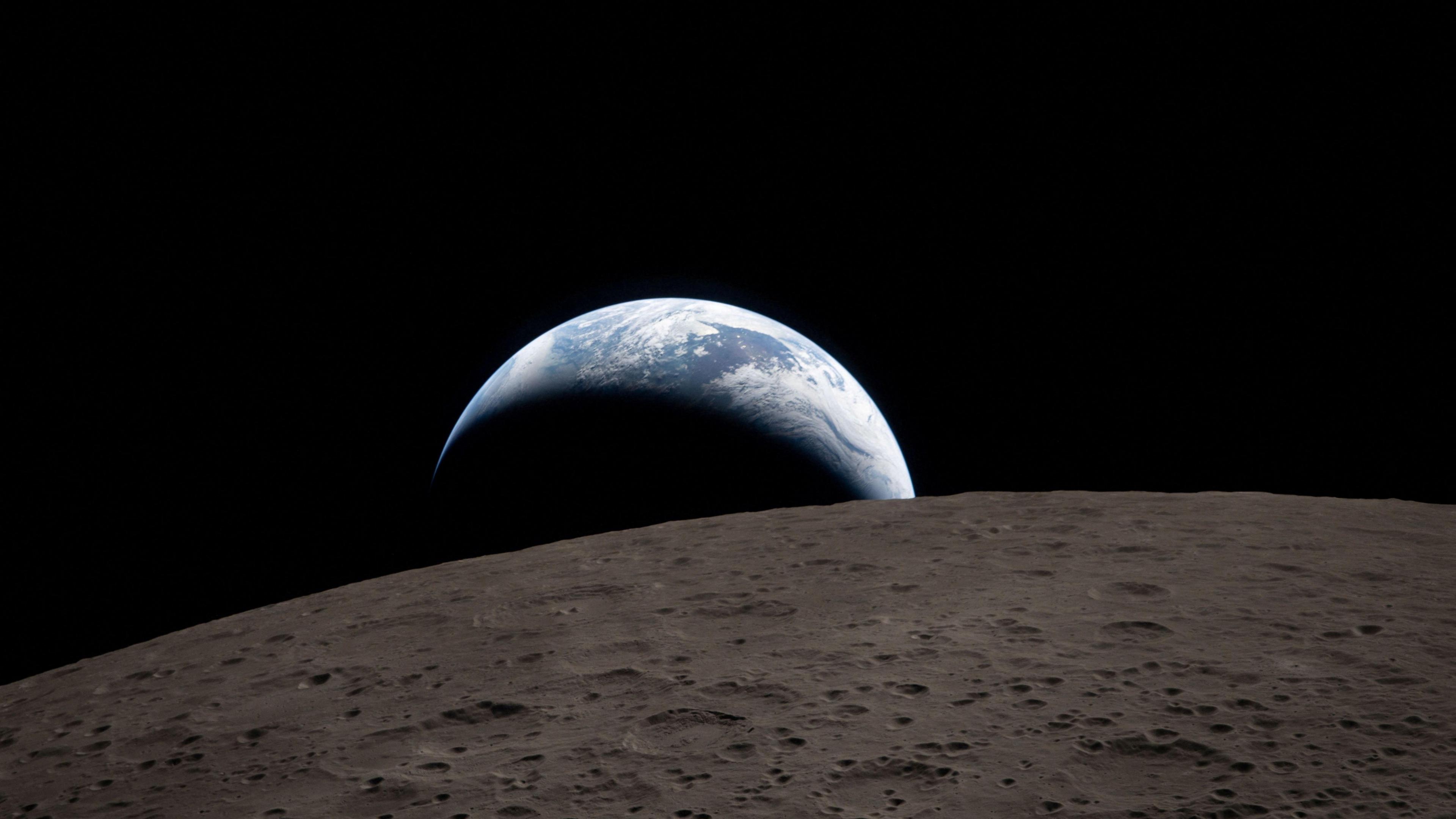 A view of Earth, partially hidden behind the Moon, captured through the Orion spacecraft window