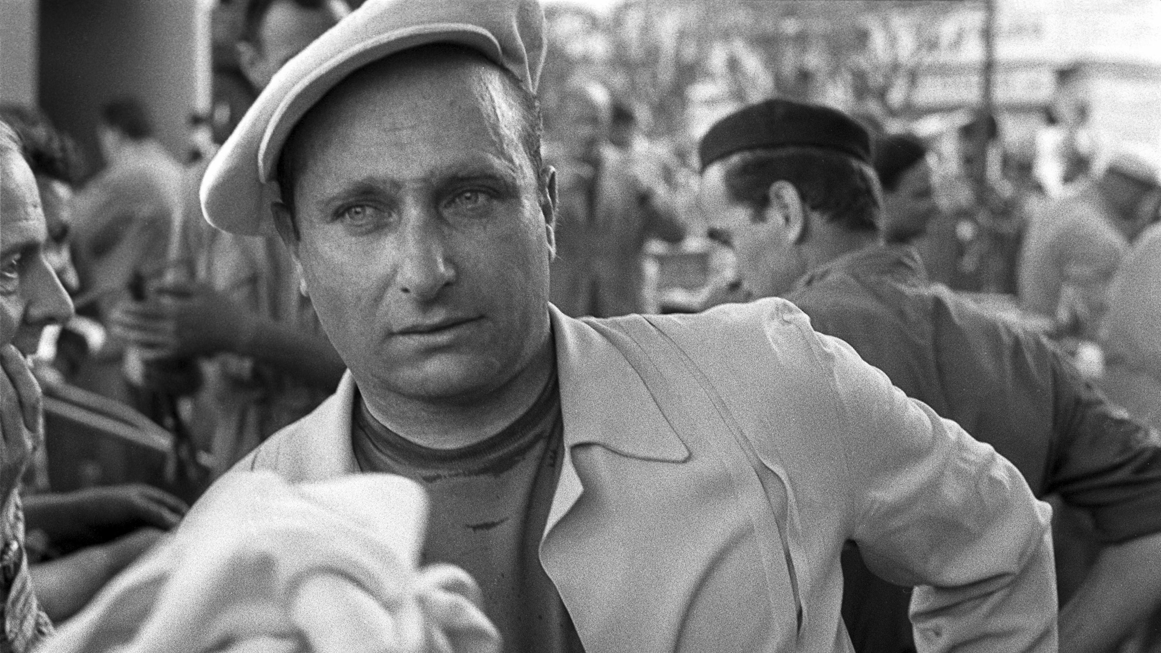 Juan Manuel Fangio pictured wearing a beret at the 1956 Monaco Grand Prix