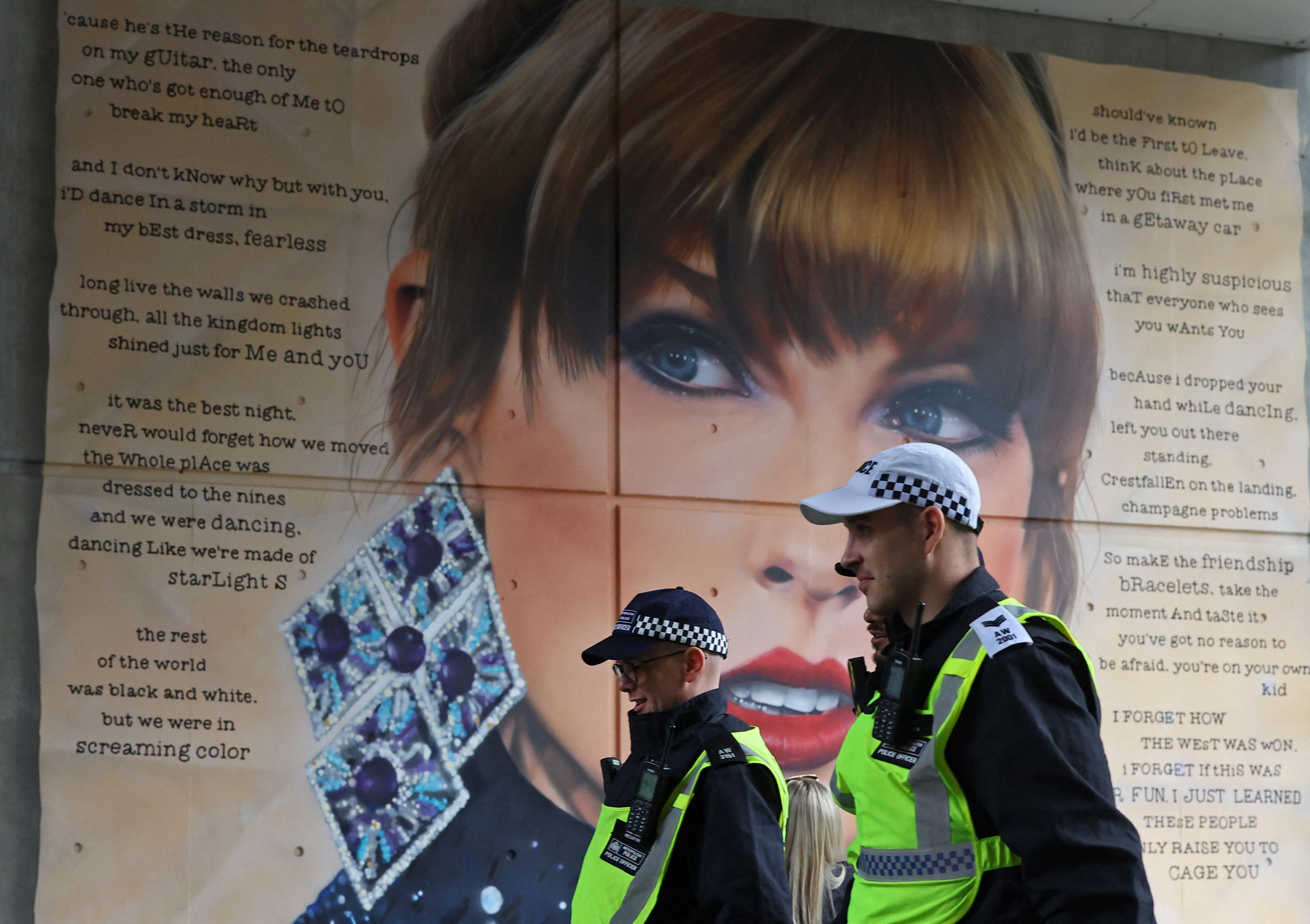 Police officers walk past a mural of Taylor Swift whilst on duty for Community Shield football match, at Wembley Stadium in London