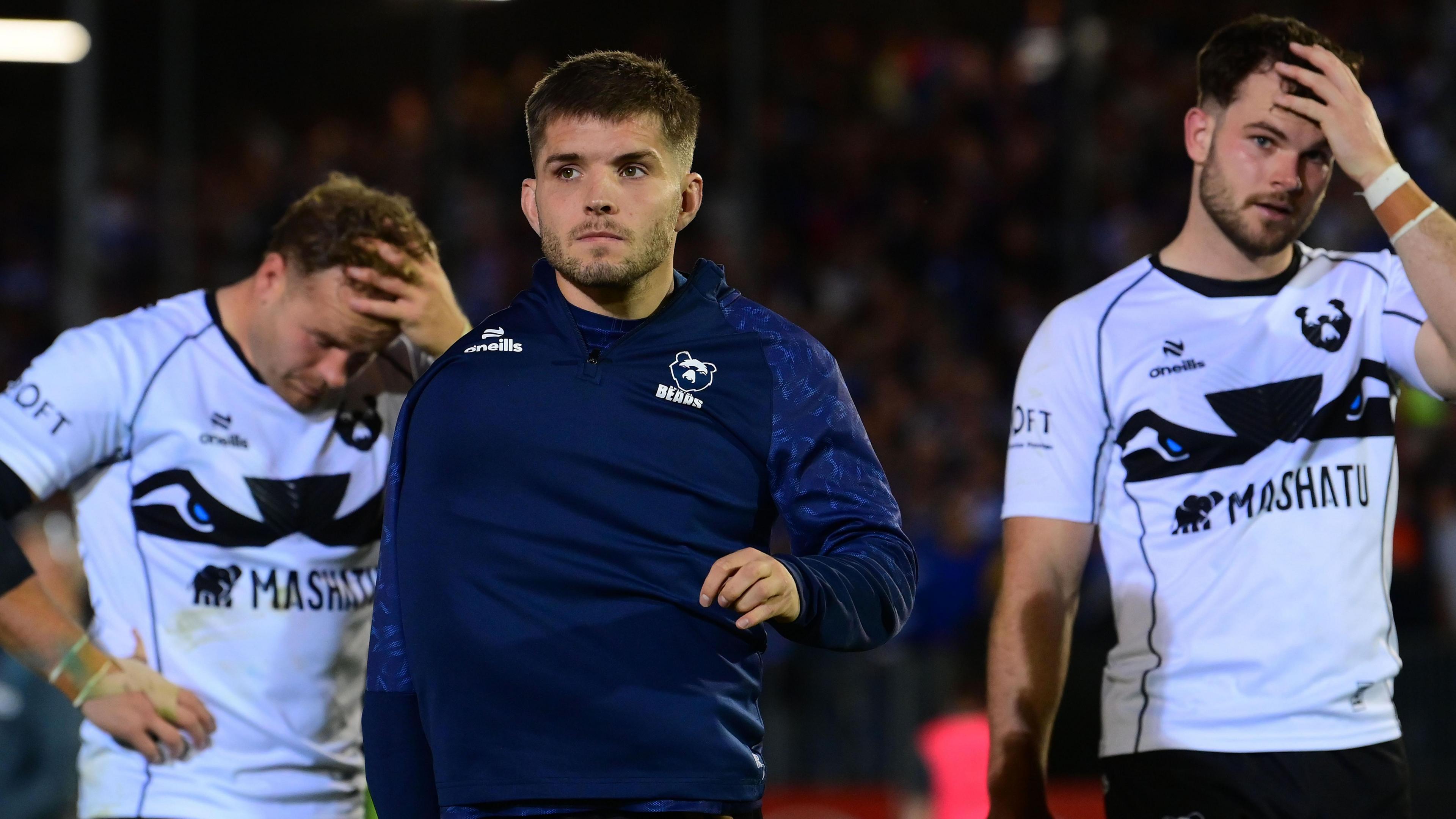 Harry Randall (centre) walks on the pitch at full-time with two disappointed team-mates behind him