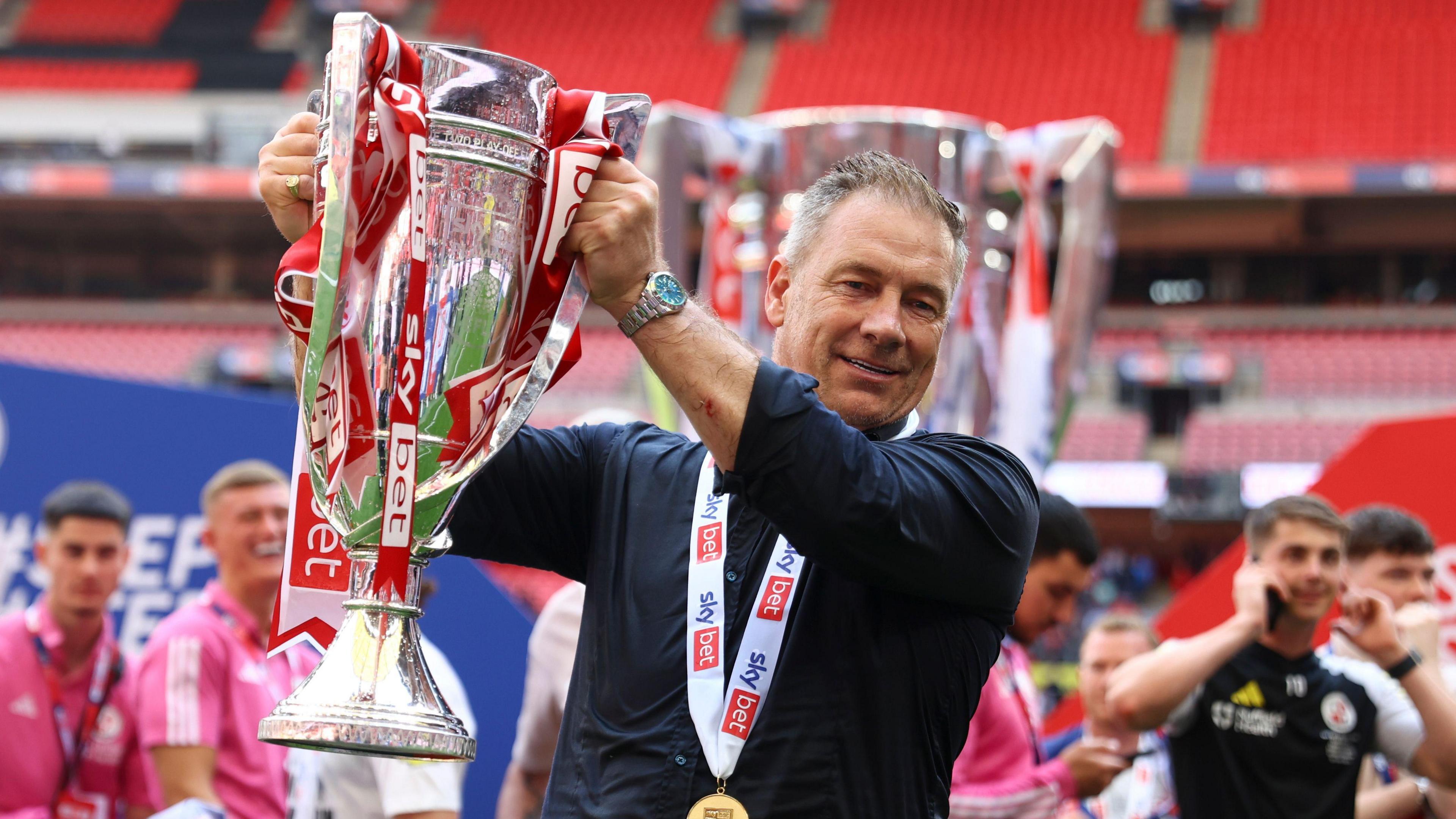 Scott Lindsey holding the trophy after winning promotion to League One with Crawley in the League Two play-off final