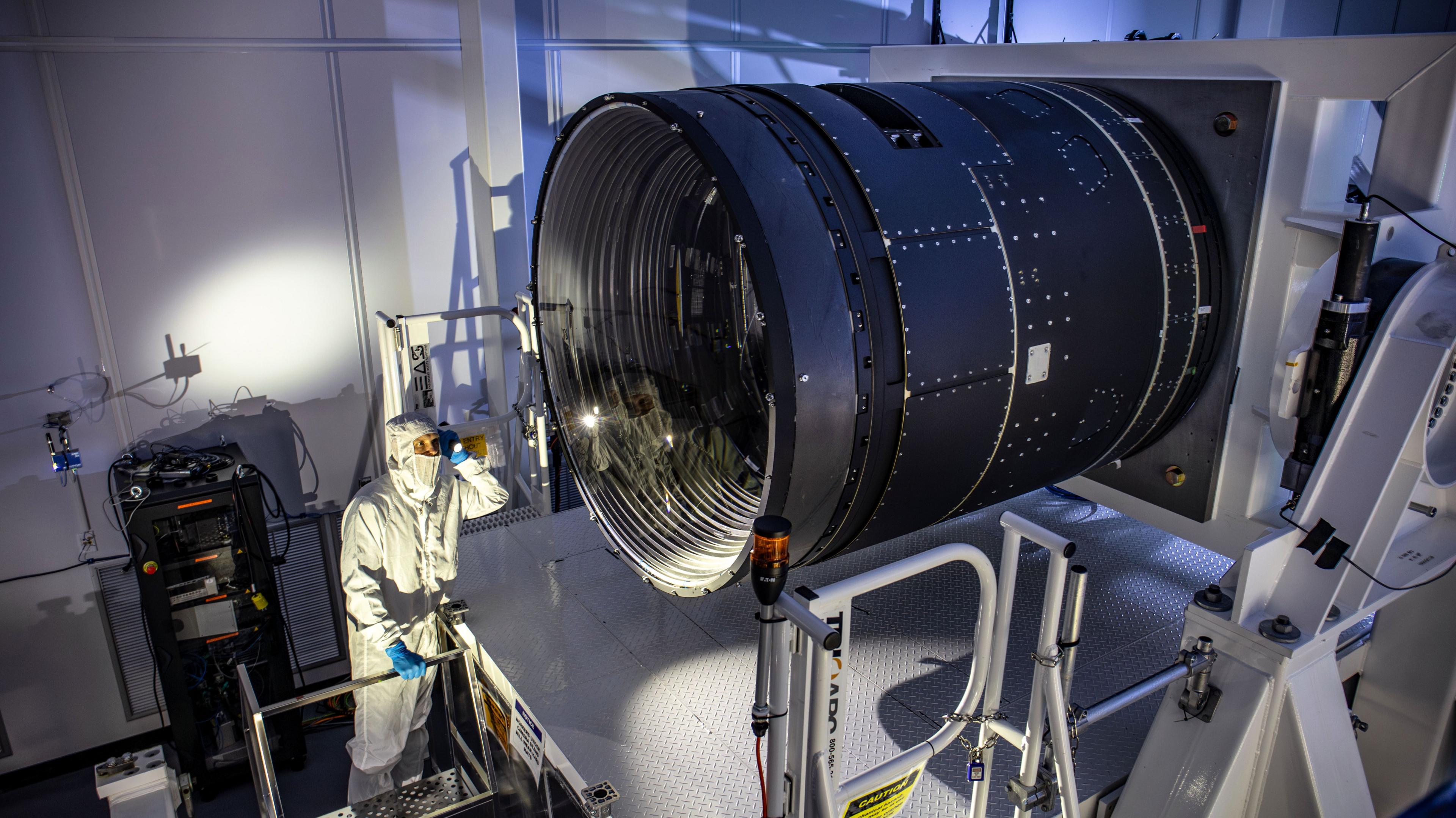 LSST Camera Deputy Project Manager Travis Lange shines a flashlight into the LSST Camera.