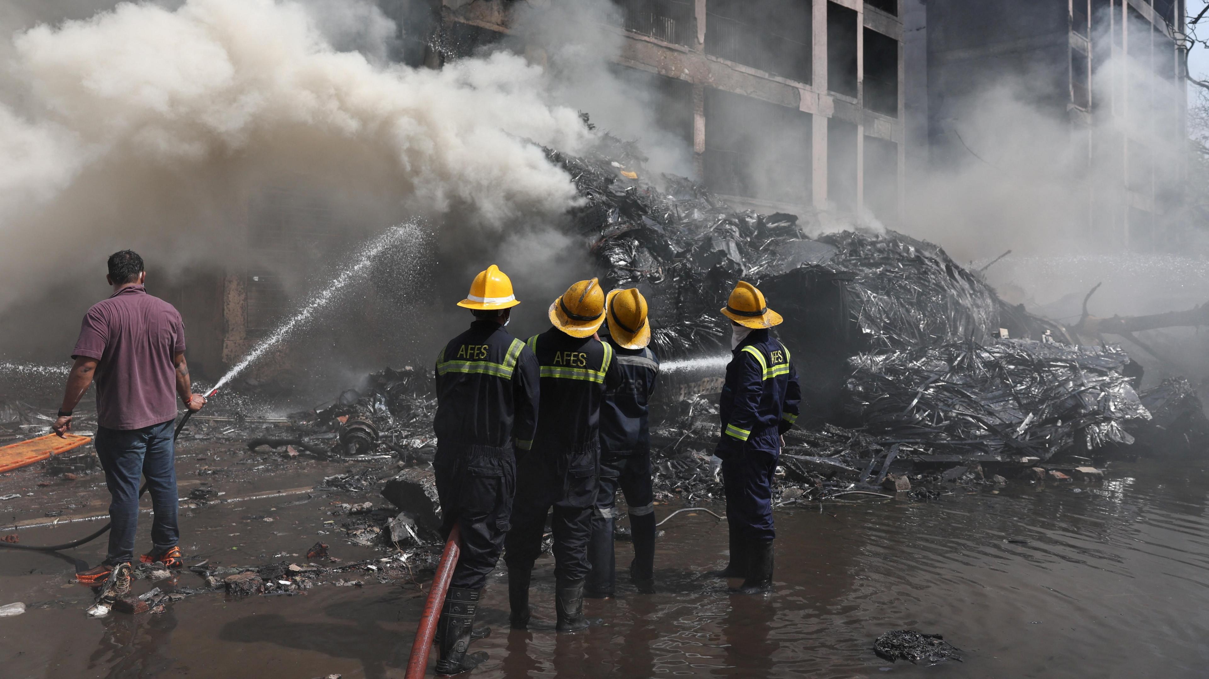 Firefighters work to put out a fire at the site where an Air India plane crashed in Ahmedabad, India, June 12, 2025