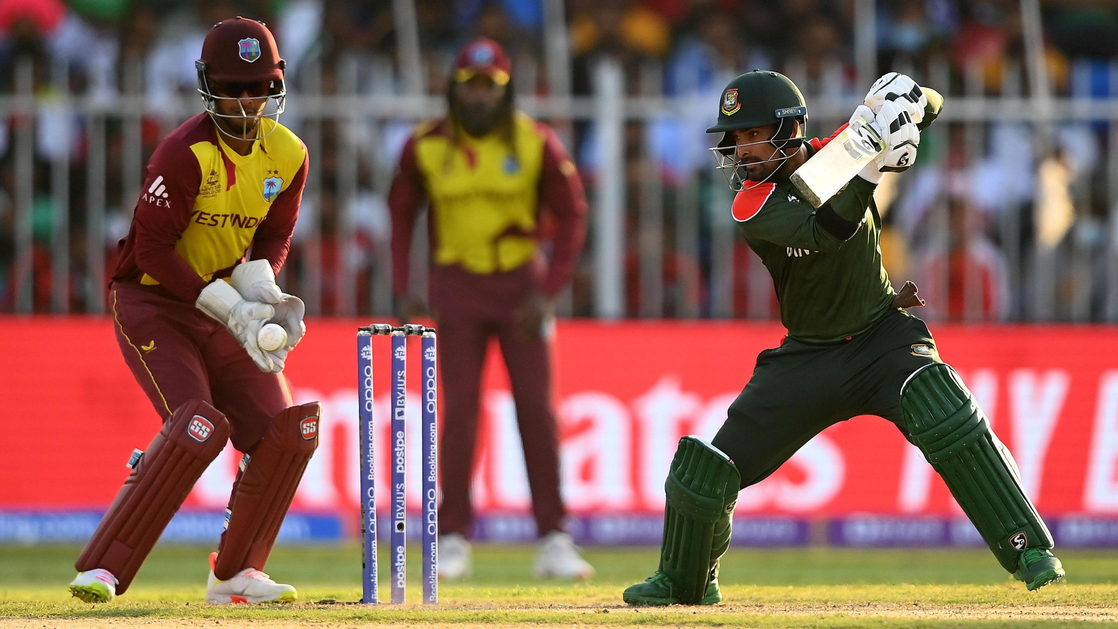 Bangladesh batter Litton Das hits out, watched by West Indies wicketkeeper Nicholas Pooran, in the T20 World Cup in 2021