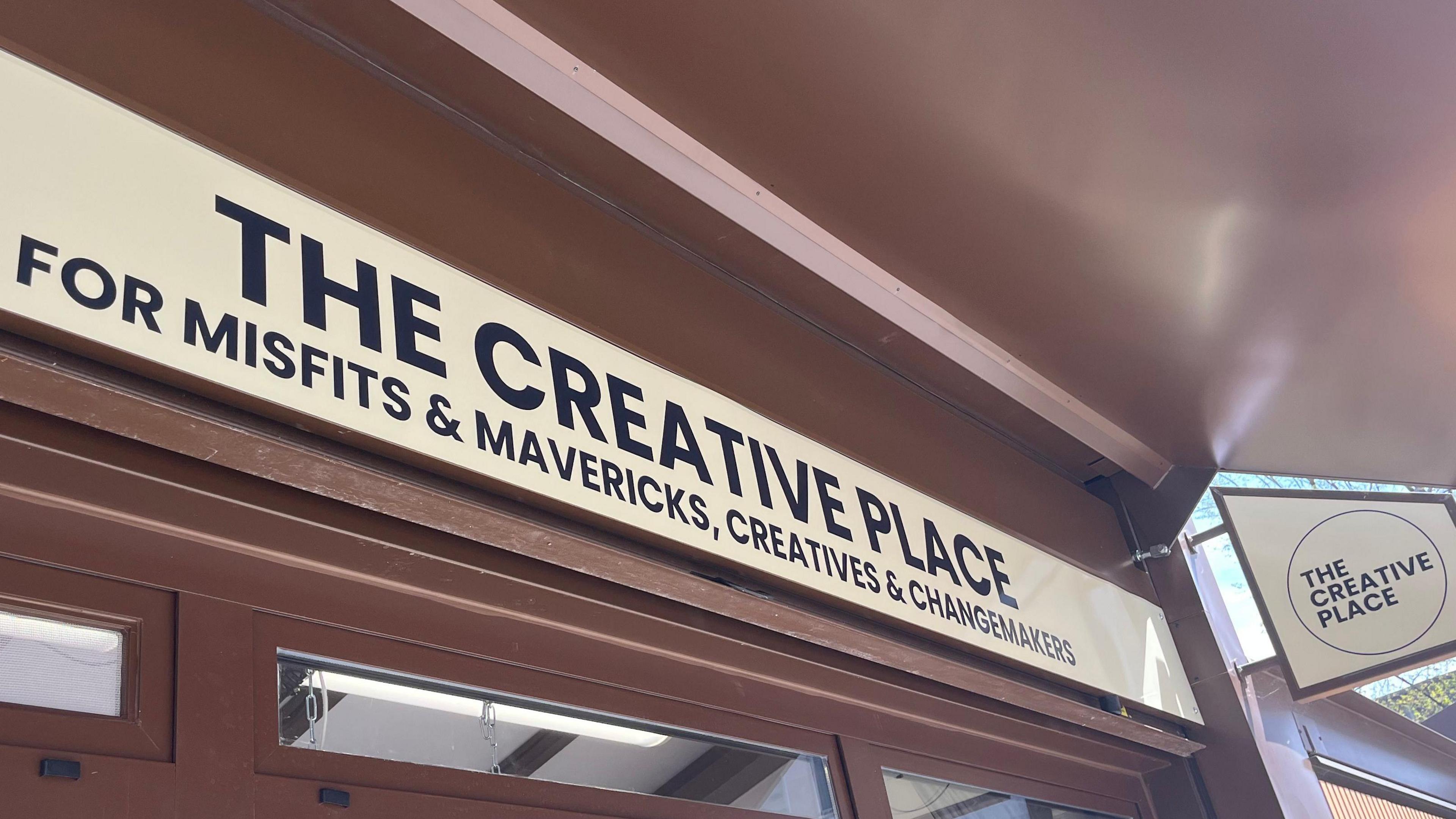 A close up of the shop front that reads "The creative place". Below it it reads "for misfits and mavericks, creatives and changemakers"