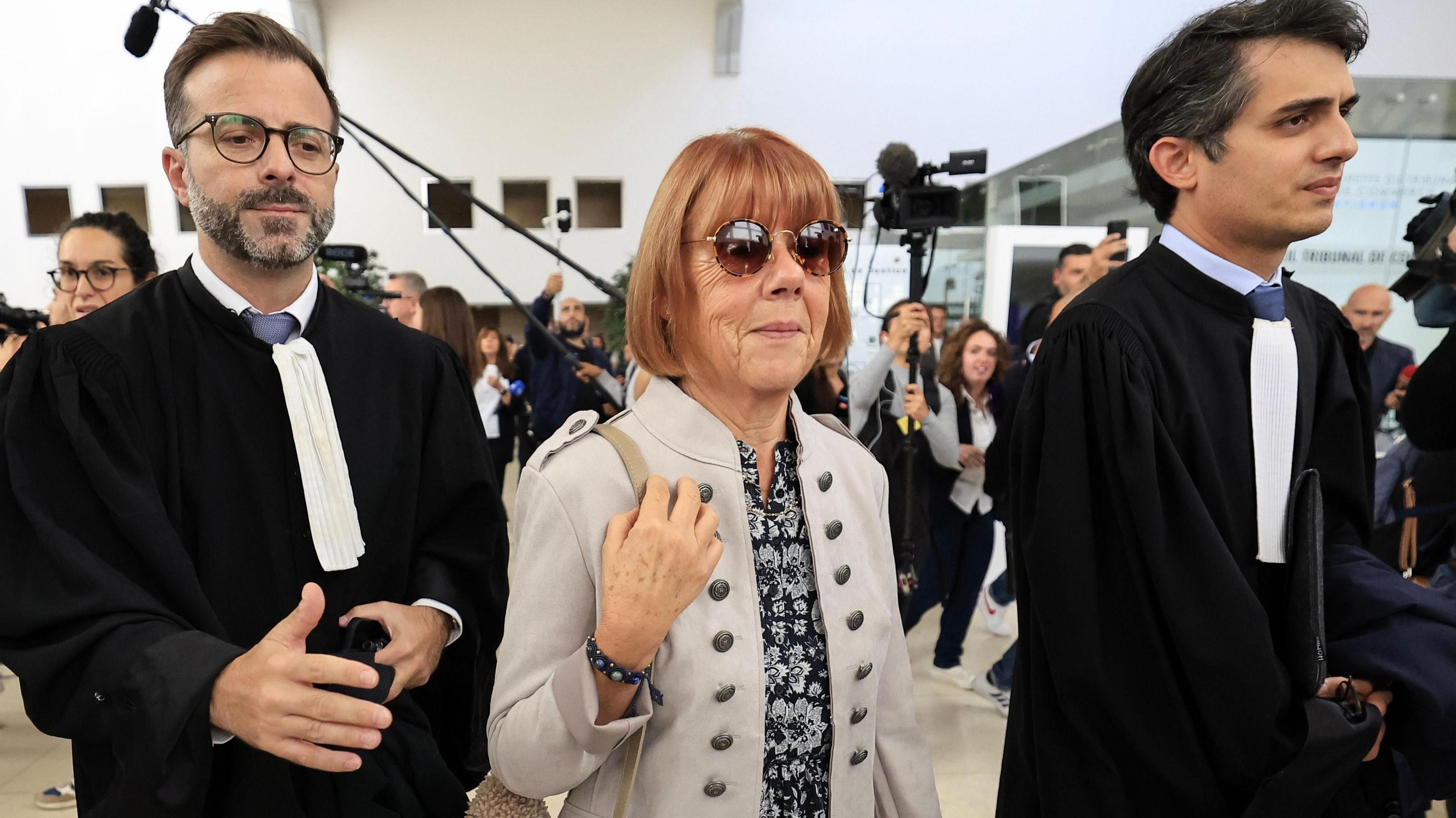 Gisele Pelicot (C), flanked by her lawyers Stephane Babonneau (R) and Antoine Camus (L), exits the criminal court in Avignon