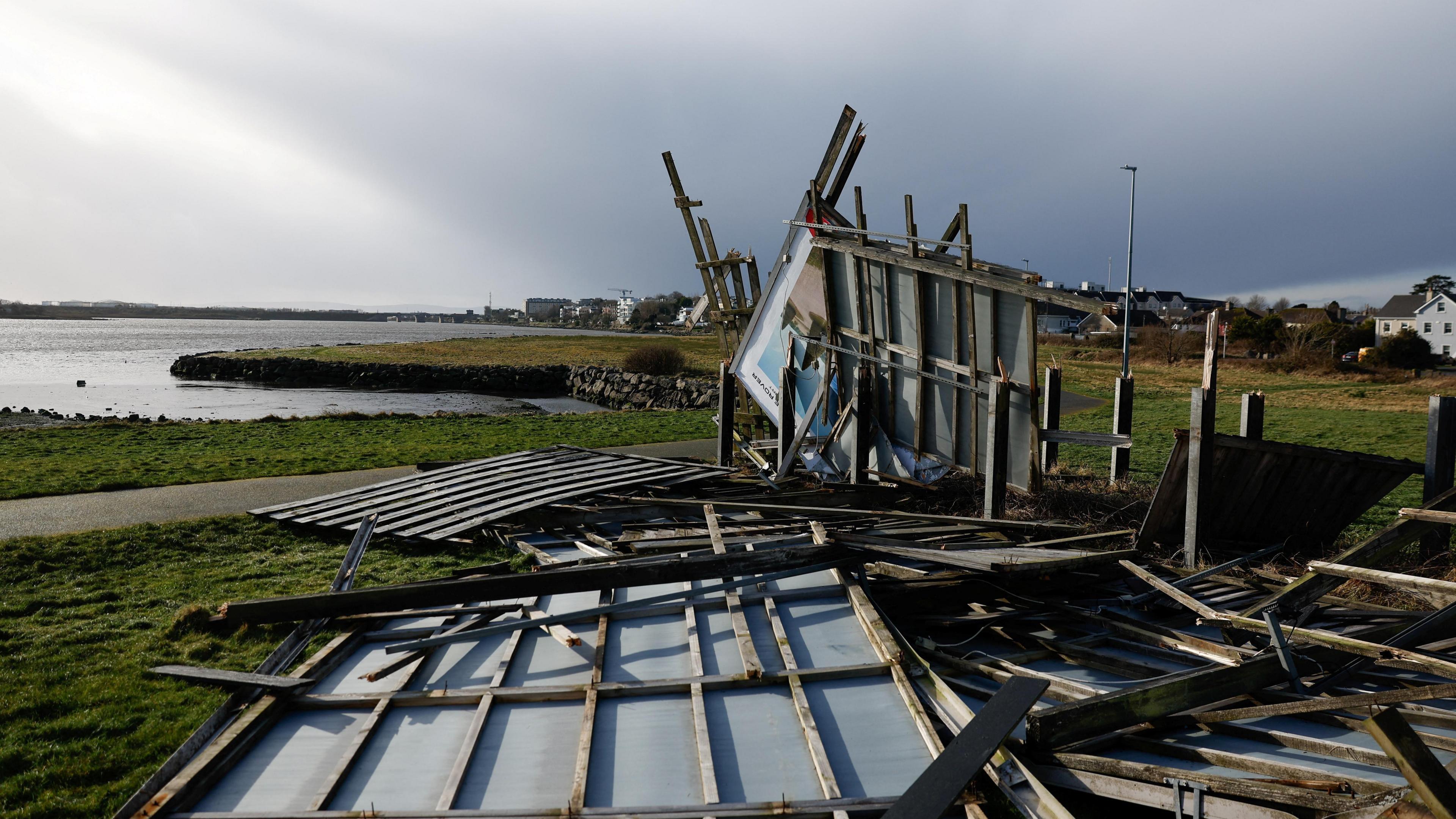 A advertising billboard destroyed during Storm Eowyn lies on the grass in Galway, Ireland.