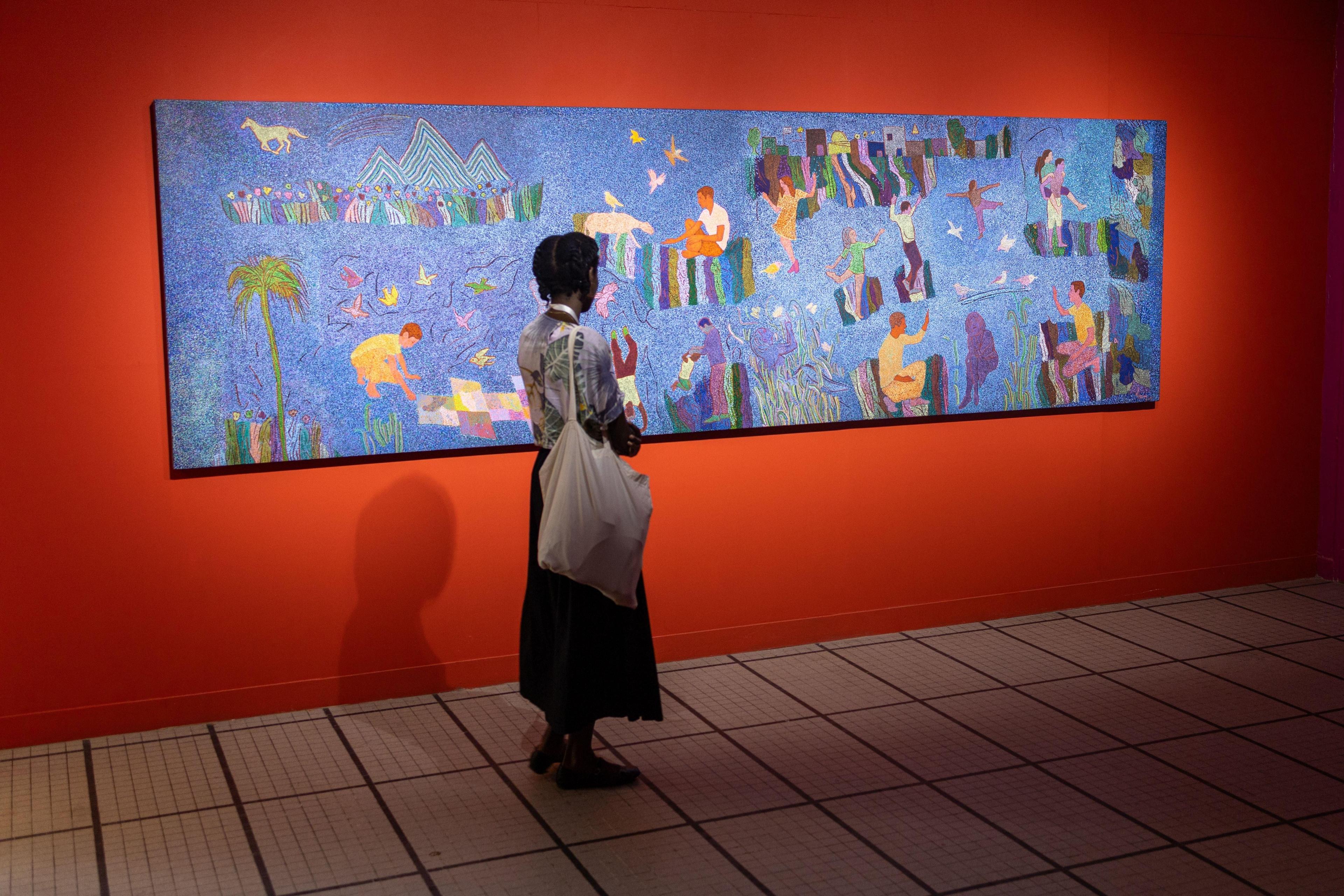 A woman looks at a big panoramic painting. 