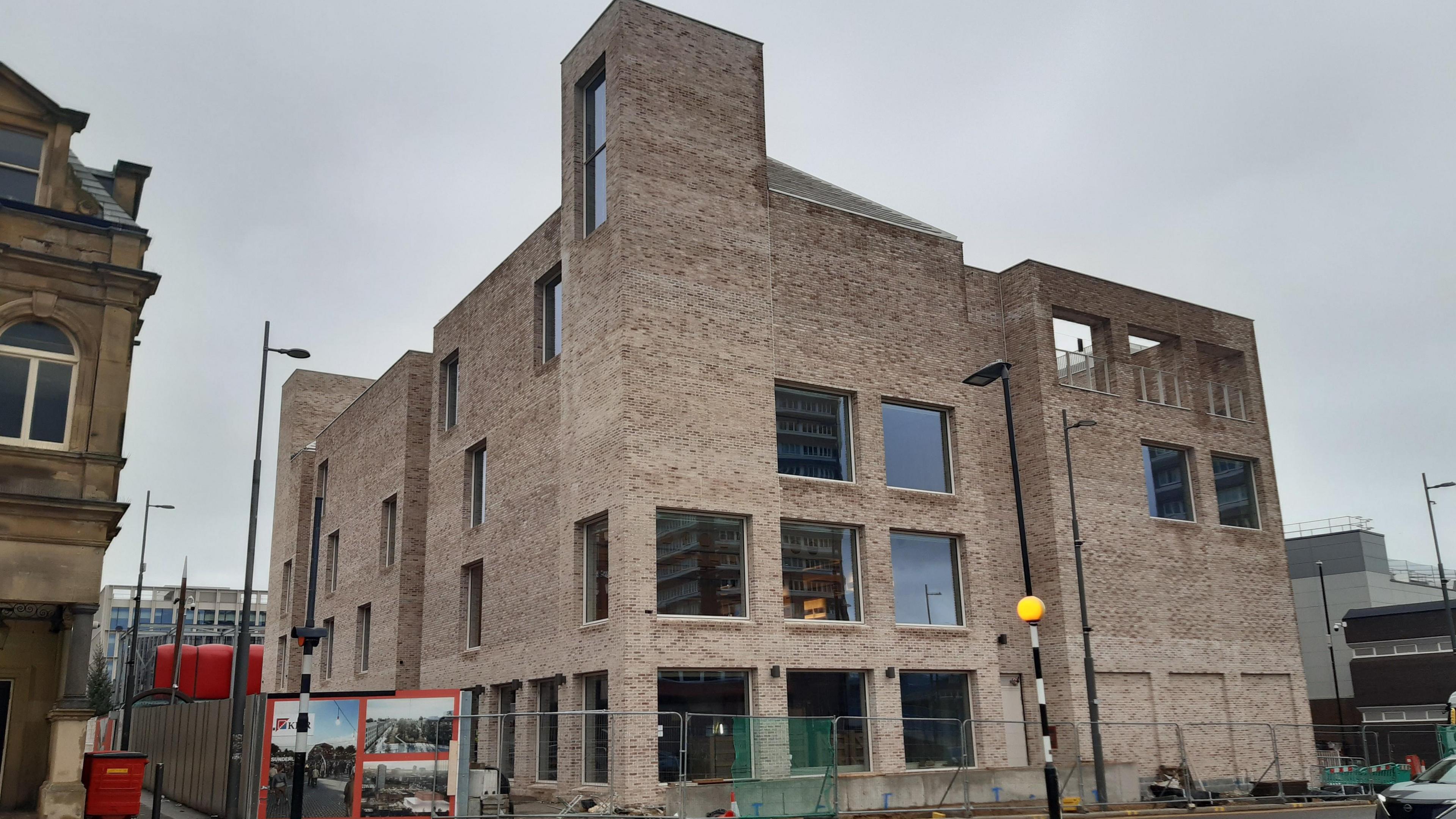 The multi-storey Culture House photographed from South Street behind Keel Square.
The brick building is fenced off. 