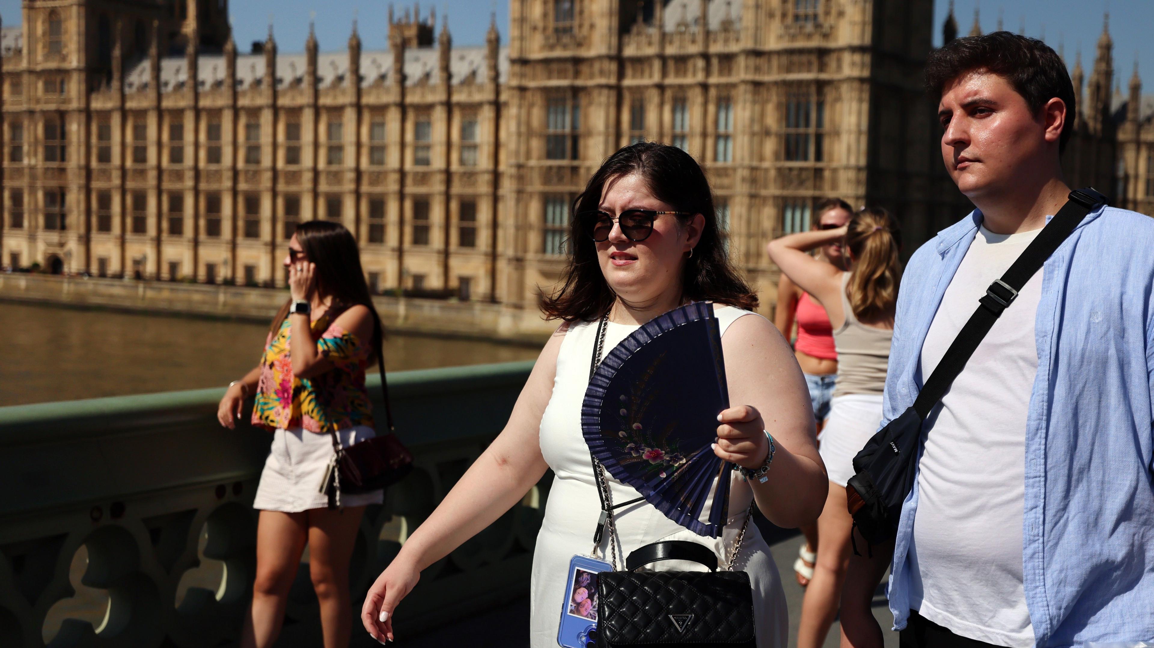 People looking hot in the sunshine with the Houses of Parliament in the background