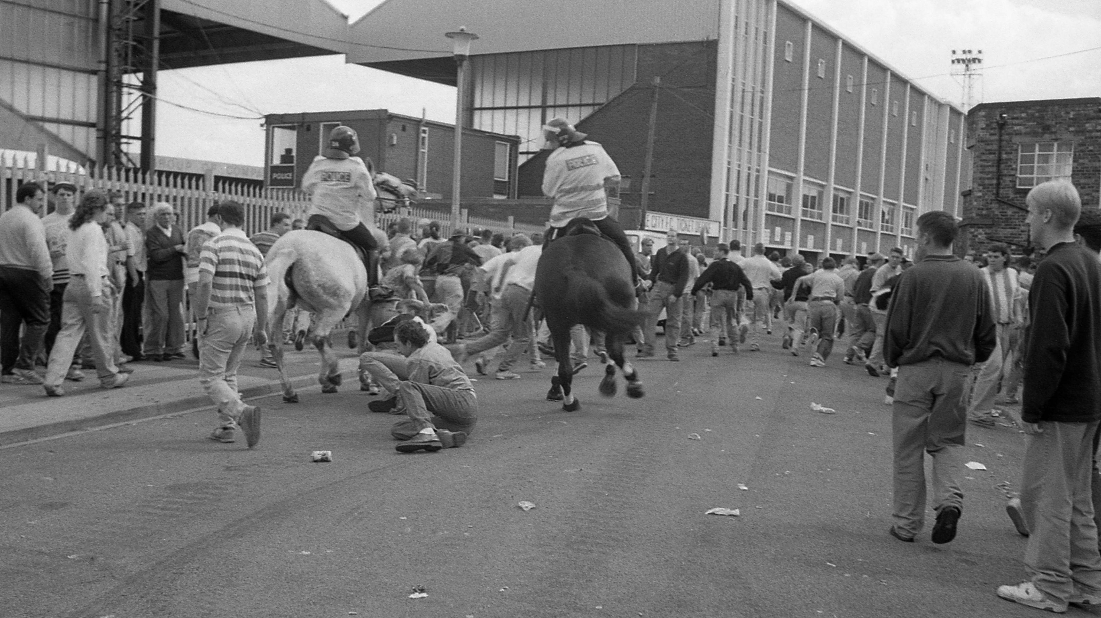 Police horses with football fans