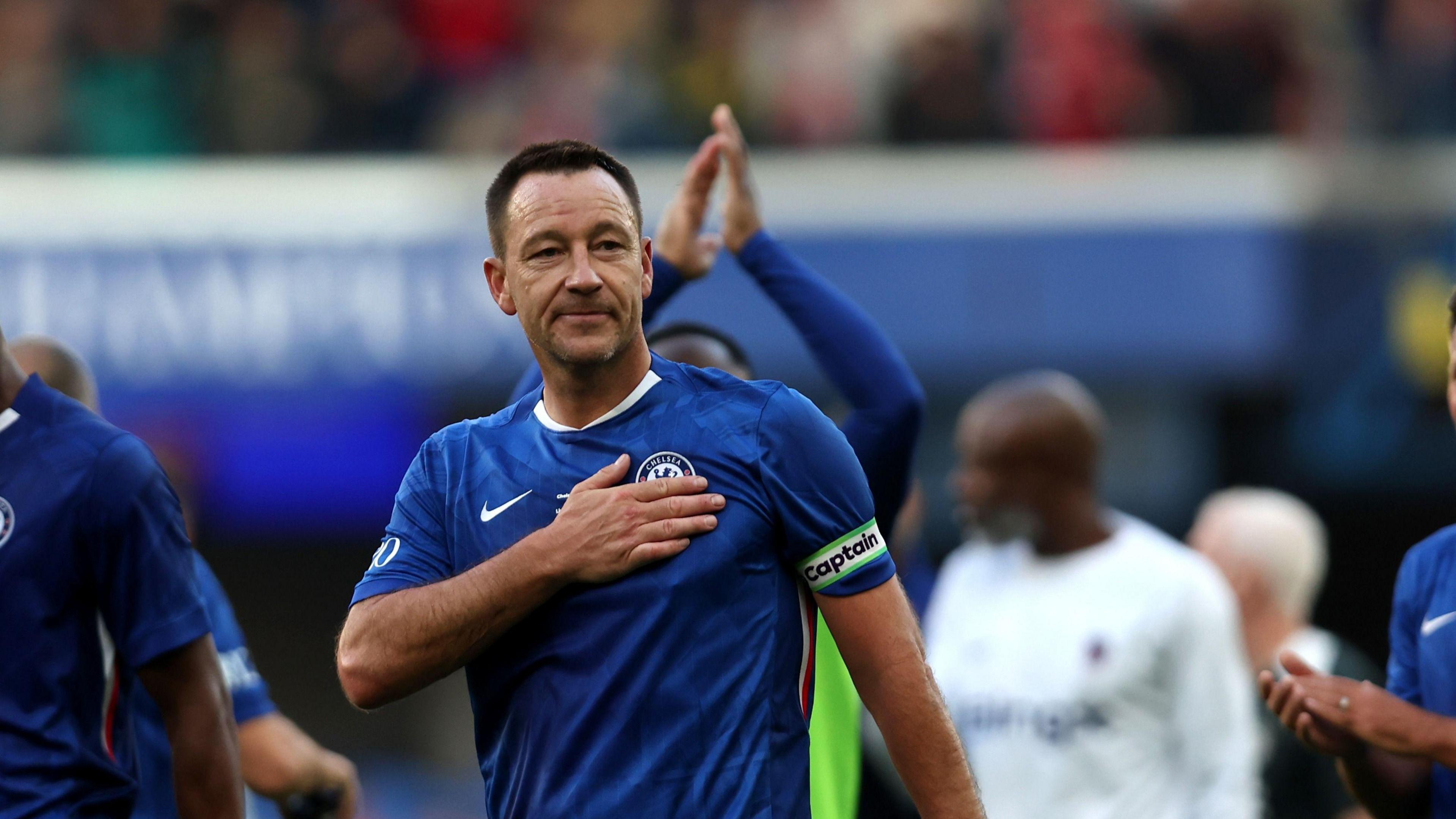 John Terry patting the Chelsea badge when captaining the legends team
