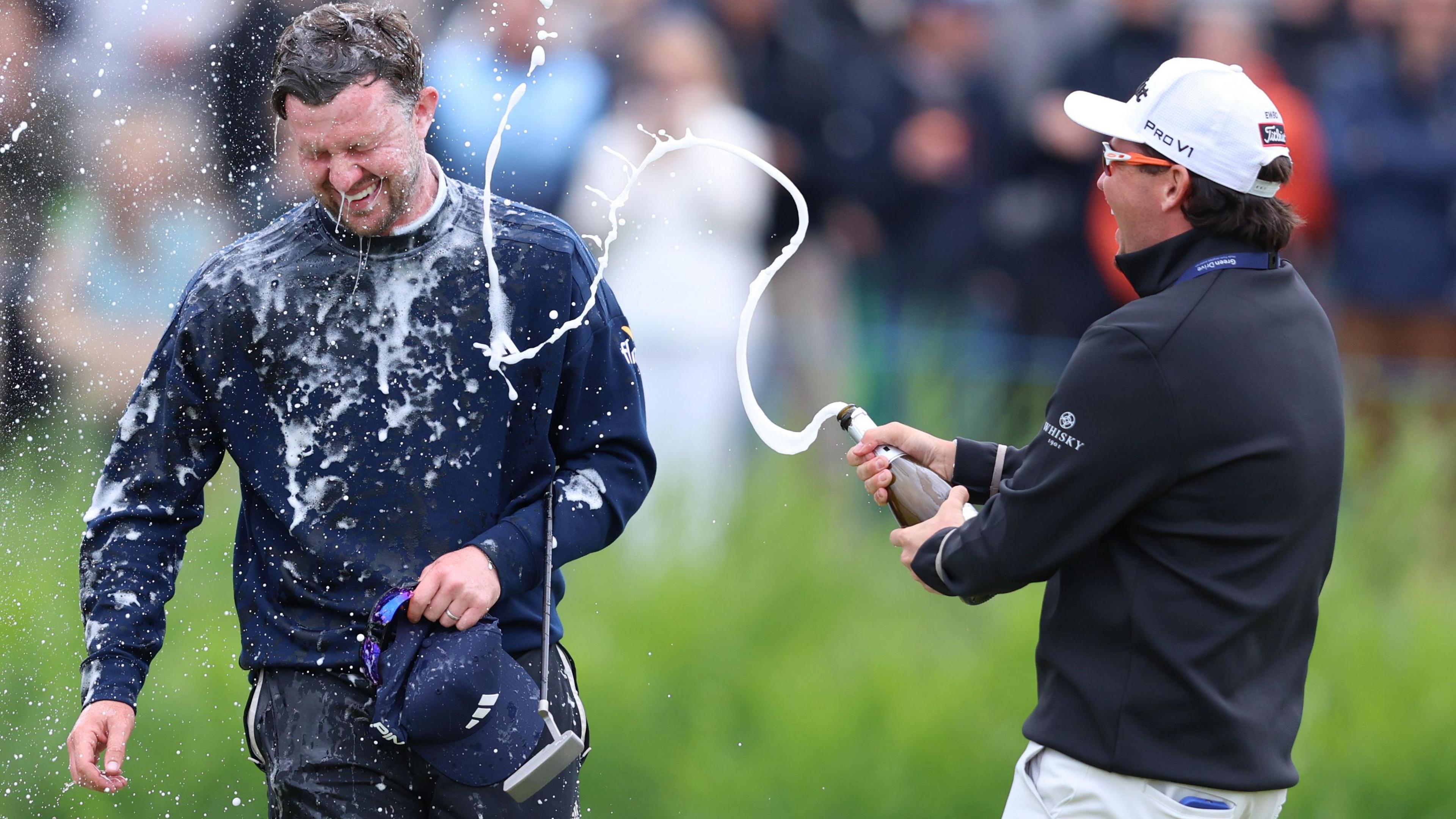 Connor Syme is sprayed with champagne by his compatriot Ewan Ferguson