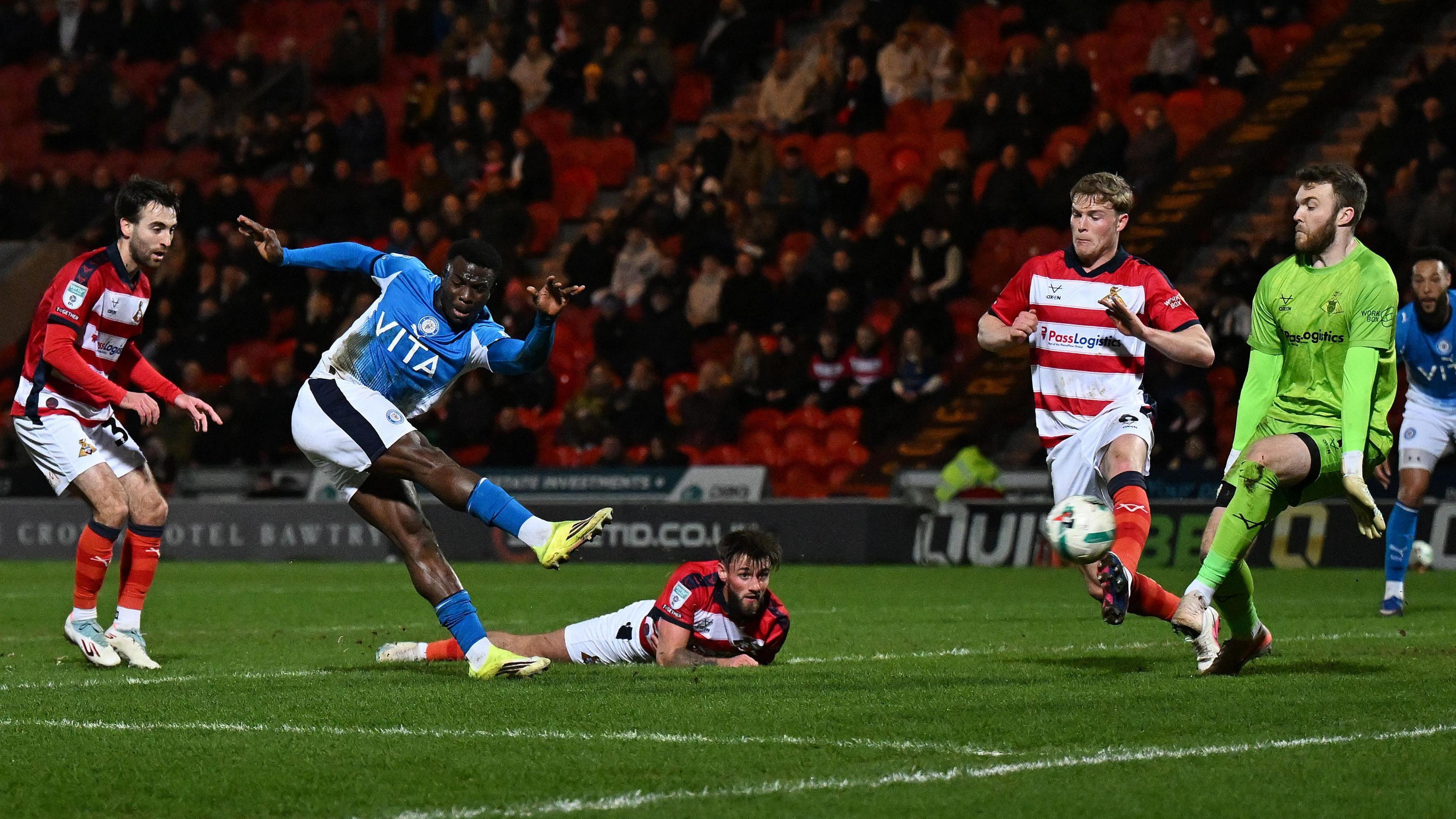 Zander Clark makes a save from Adama Sidibeh as Doncaster defenders look on