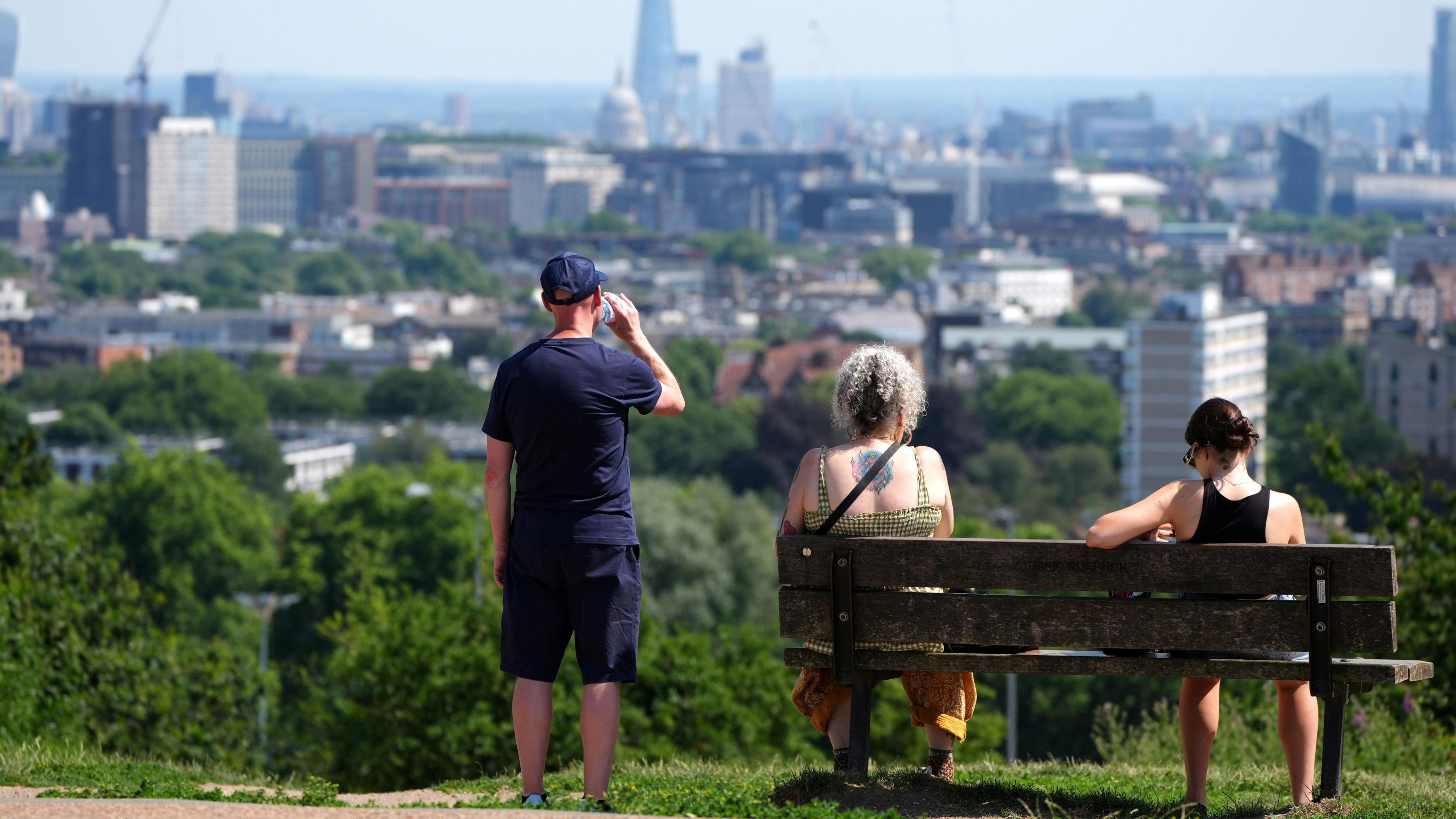 People enjoy the view from Hampstead Heath in London in heatwave conditions in July