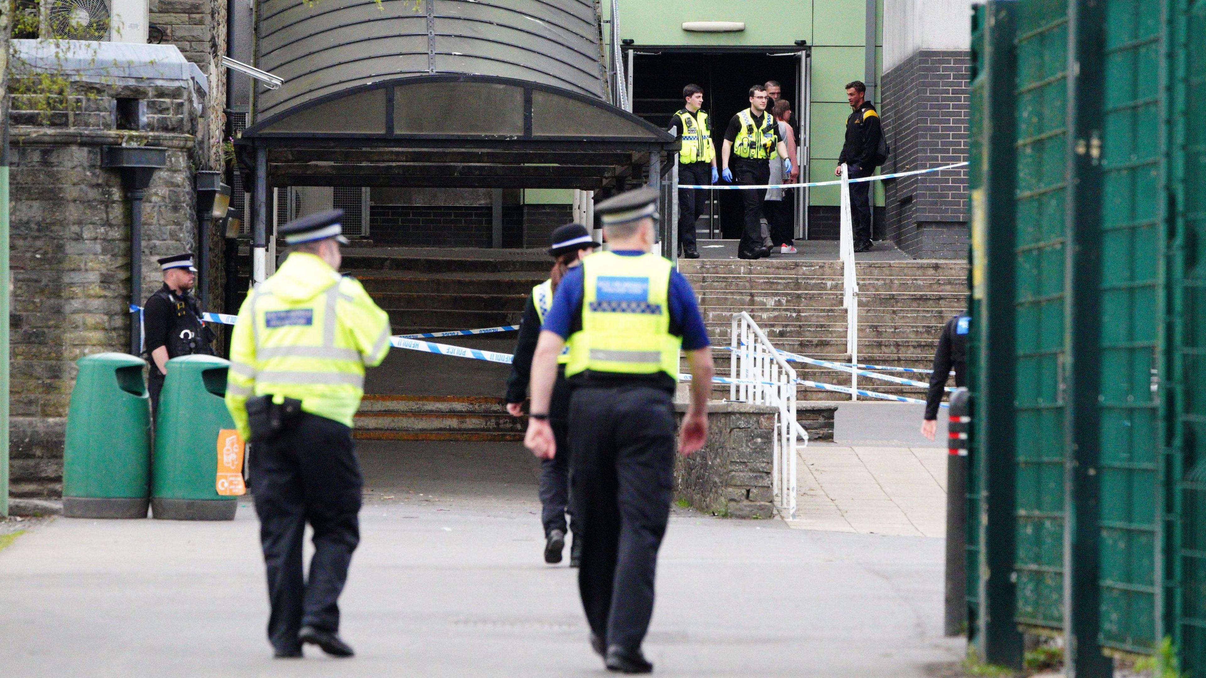 Several police officers and police cordon at the entrance to the school