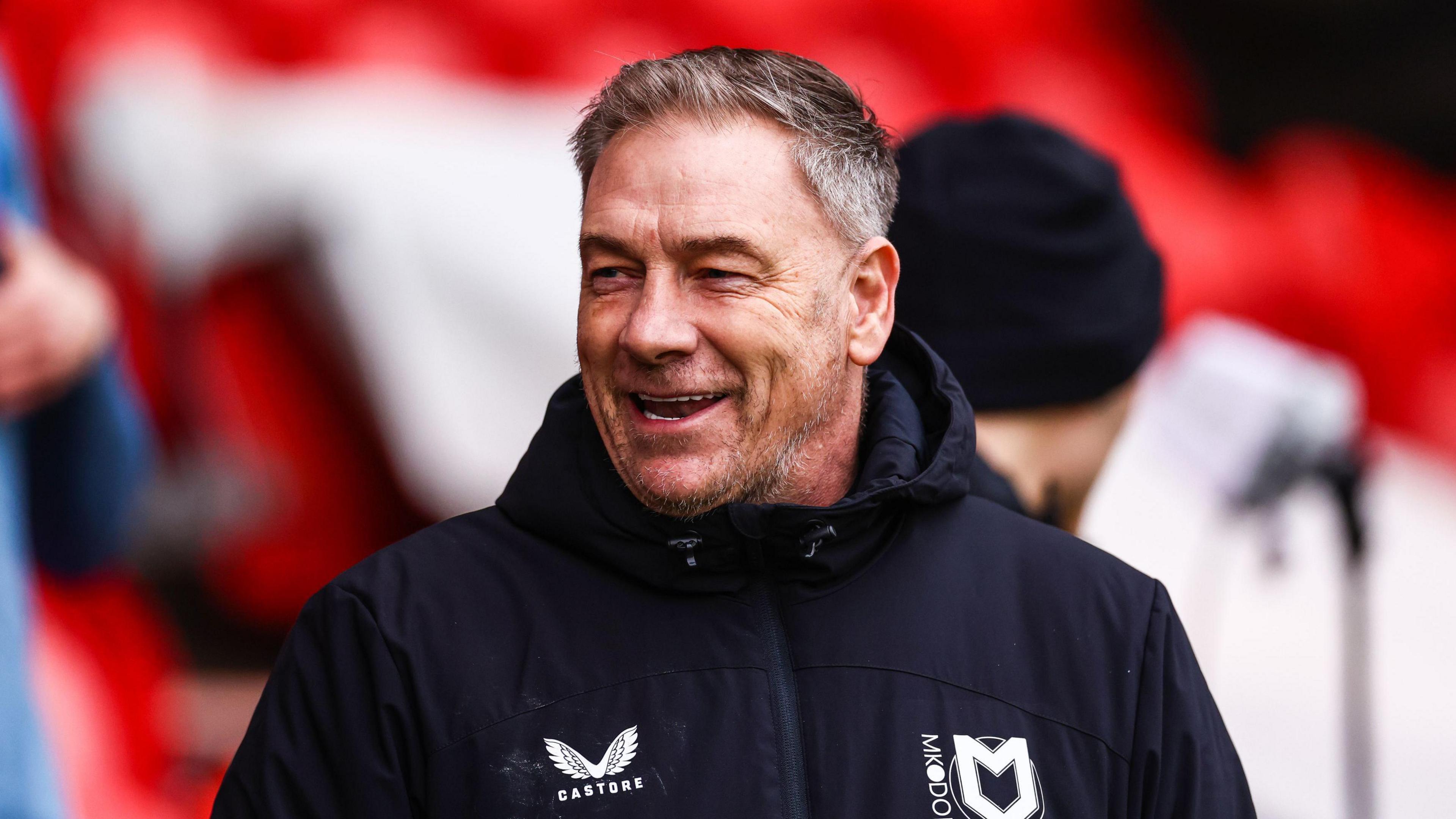 Scott Lindsey smiling on the touchline during an MK Dons match this season