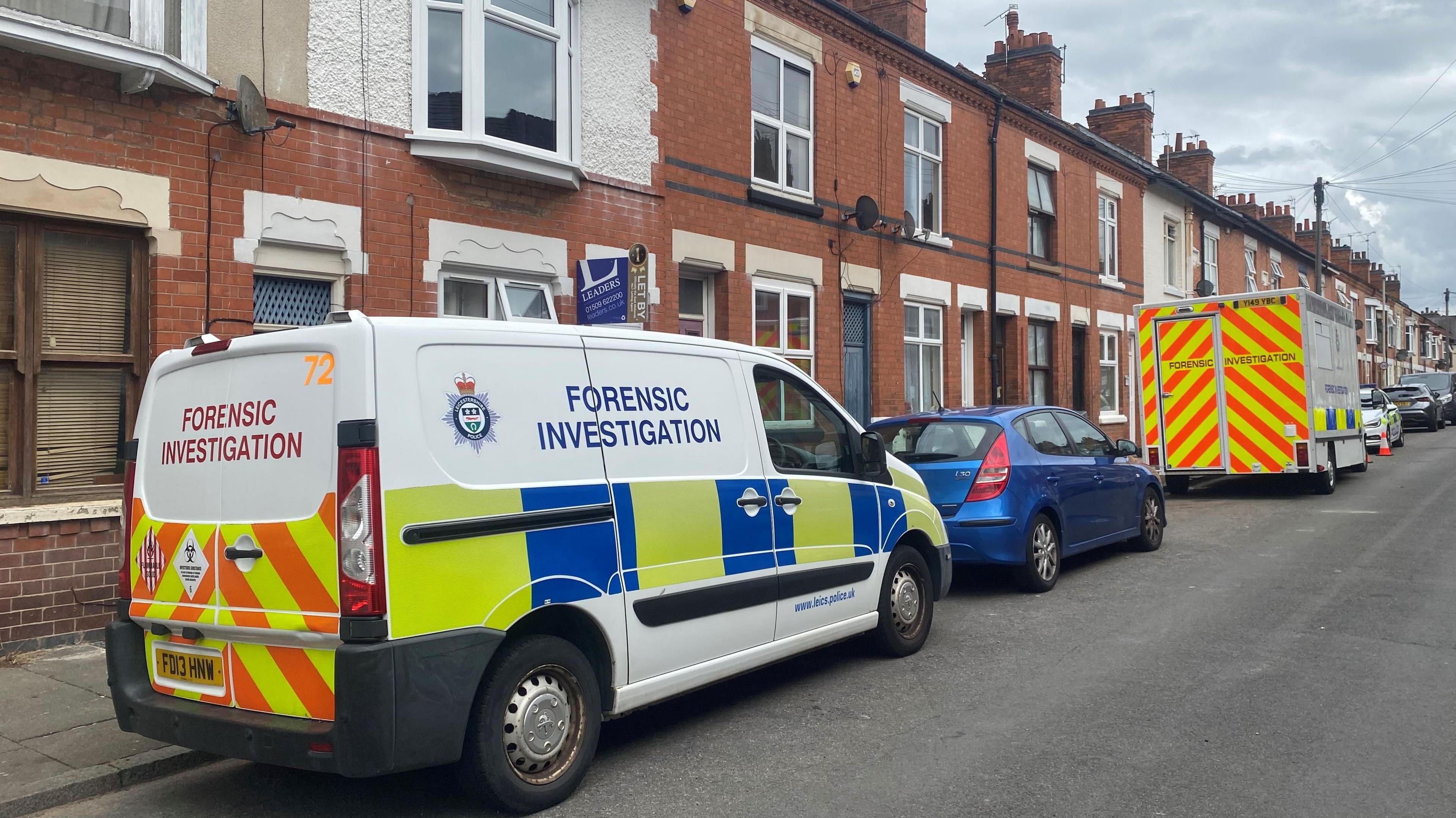 A forensic van pictured in front of terraced properties.