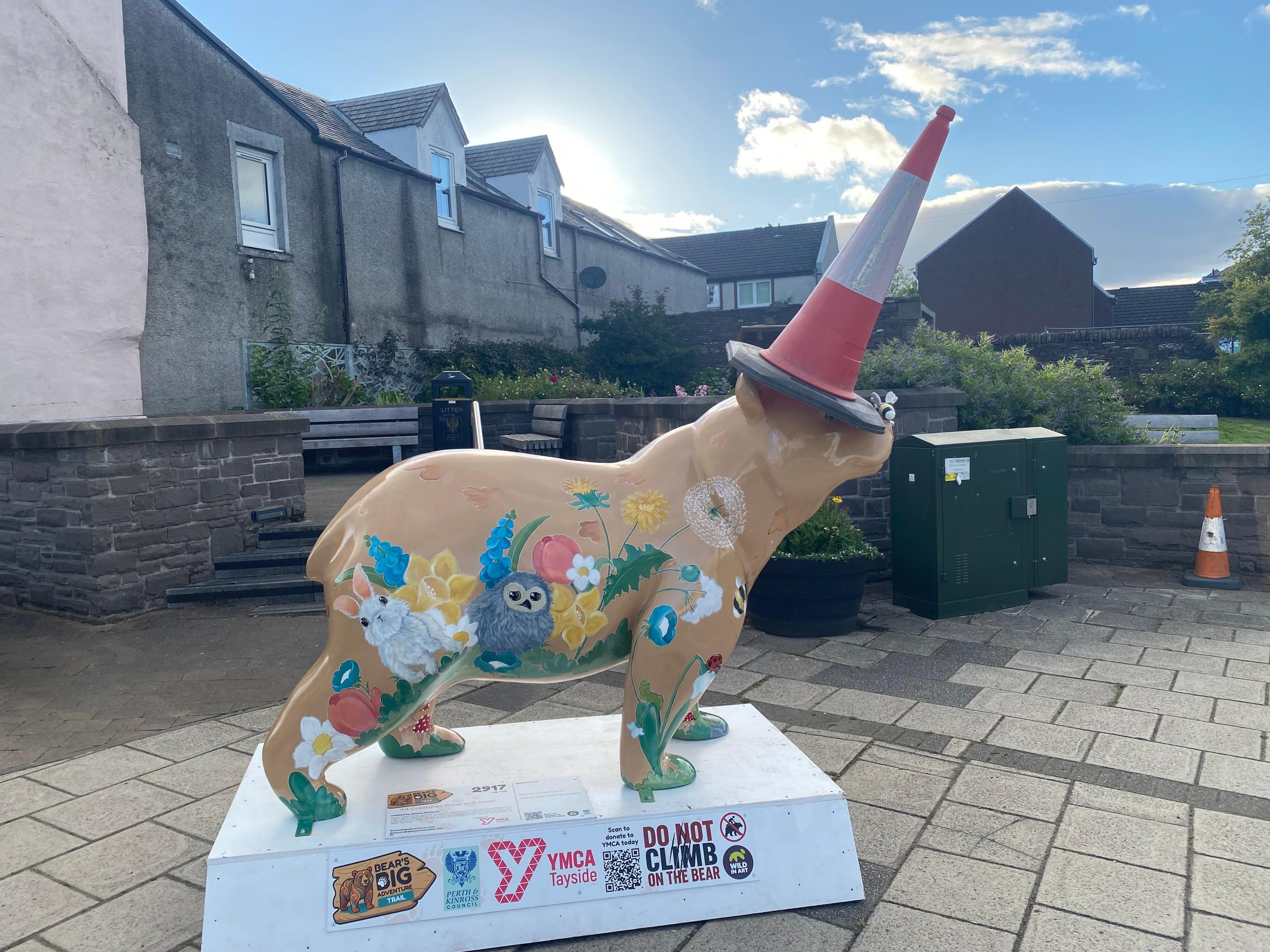 A statue of a bear with a cone on its head