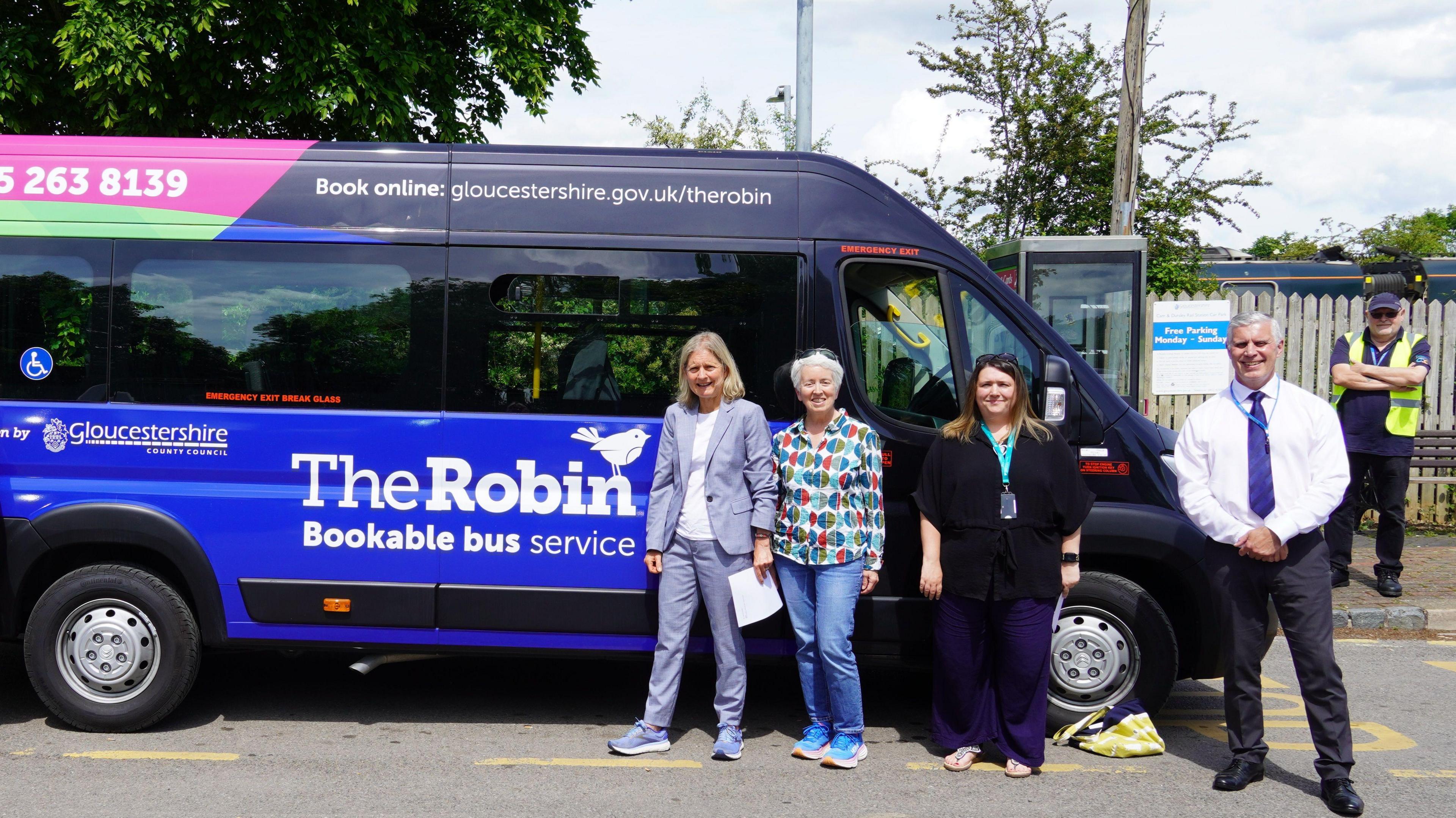 Four people stood by The Robin bus