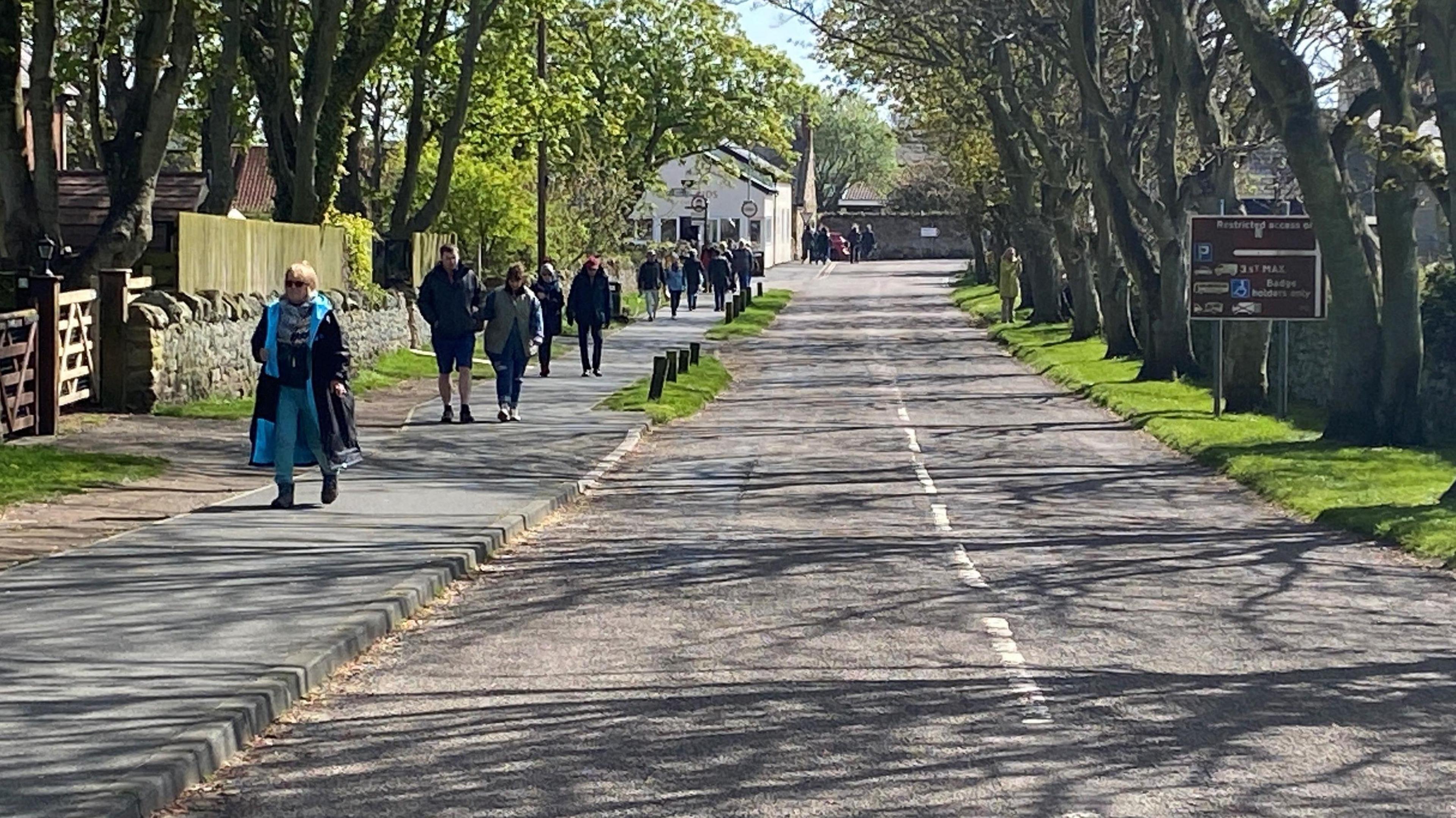 A picture of lots of people walking along a street on Holy Island 