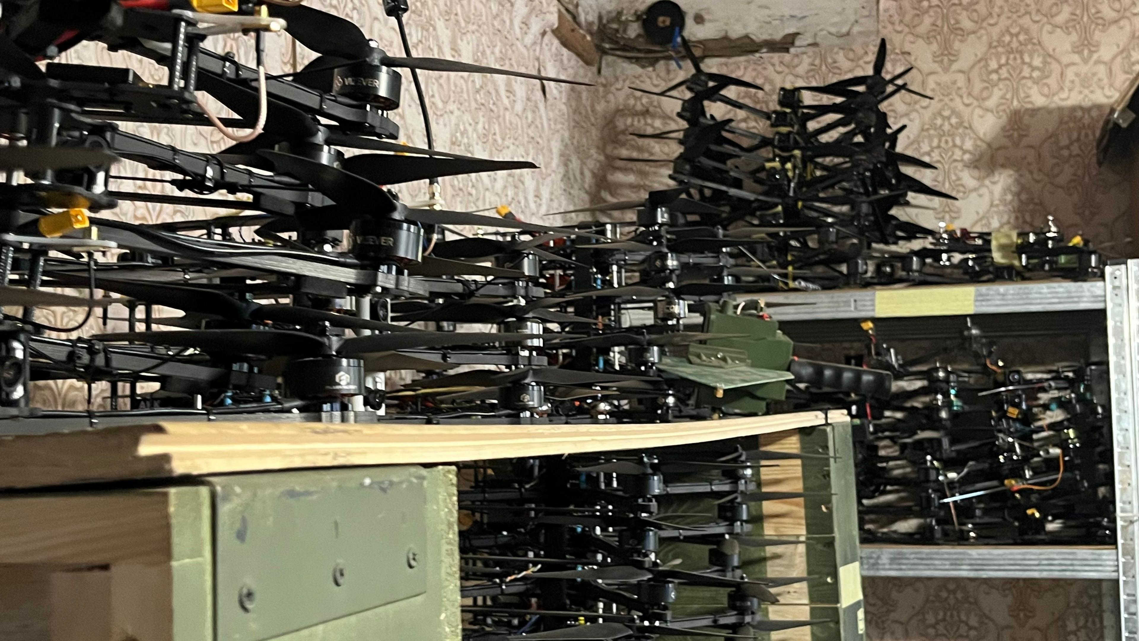 Shelves piled with small drones, waiting to be sent to the front