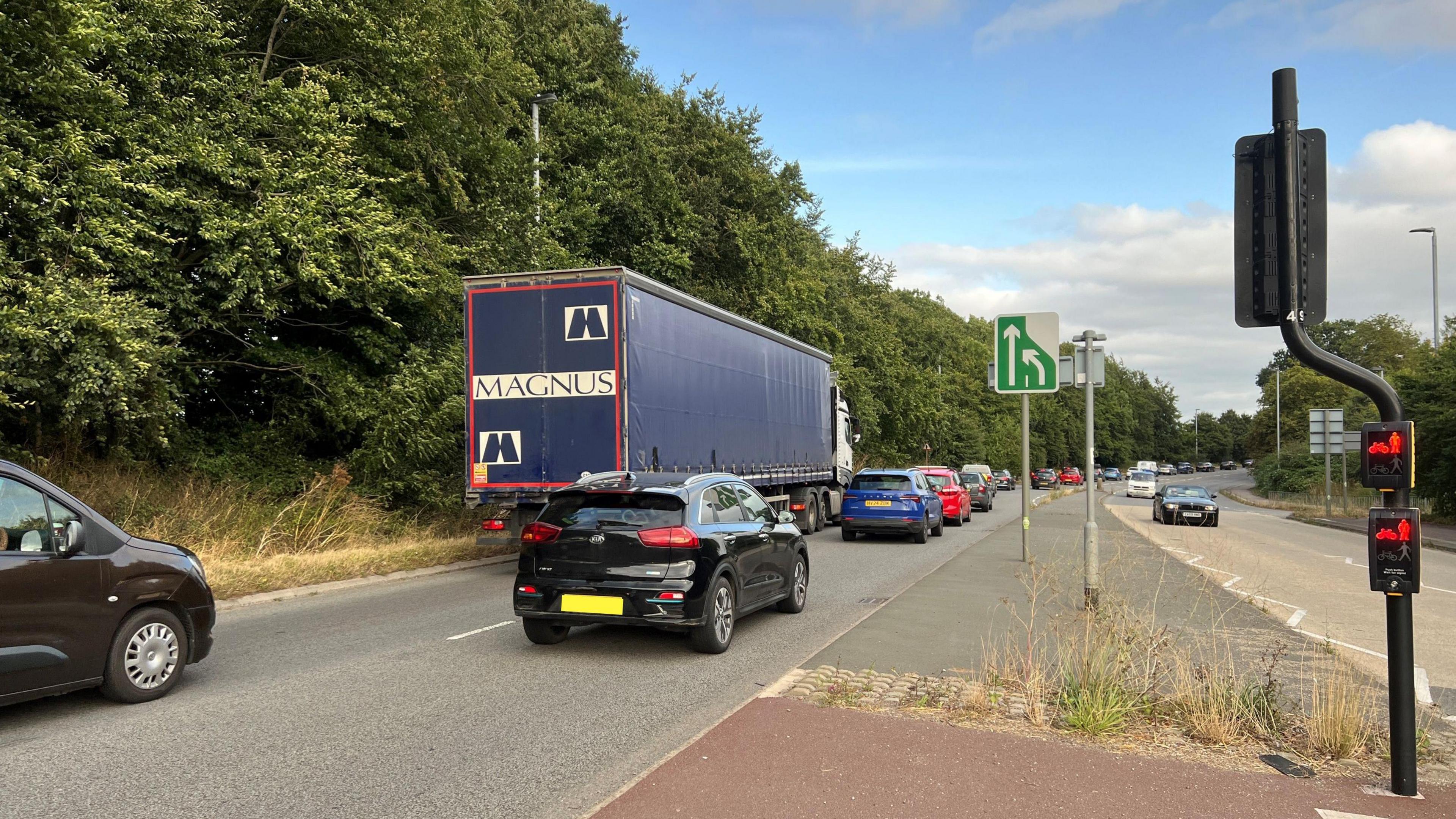 Picture of road and lorries merging in turn on the A358 with traffic lights visible in the foreground