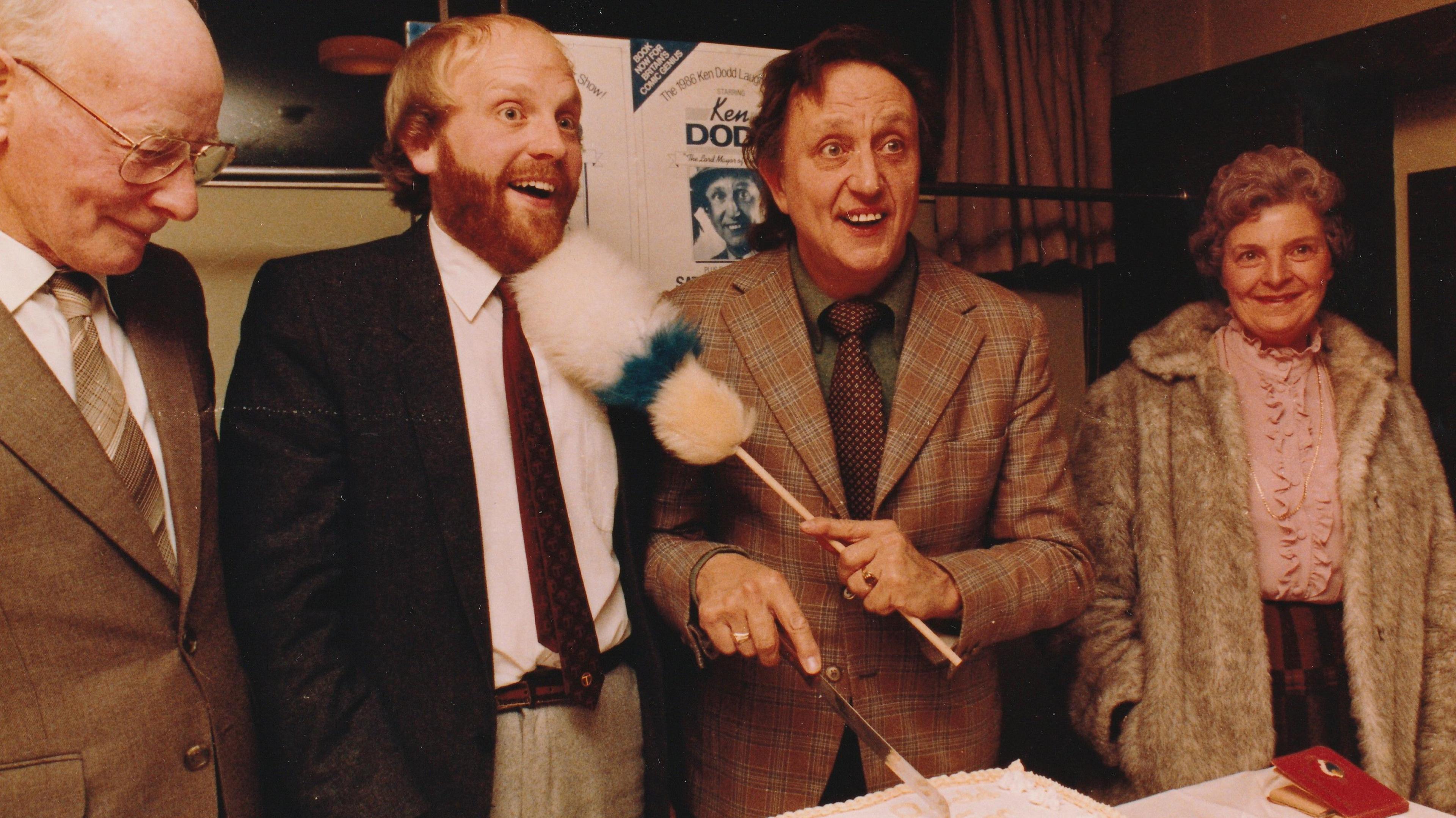 An archive photo showing Dave Latham with Ken Dodd who is waving one of his tickle sticks in Mr Latham's face. They are accompanied by two other people either side of them