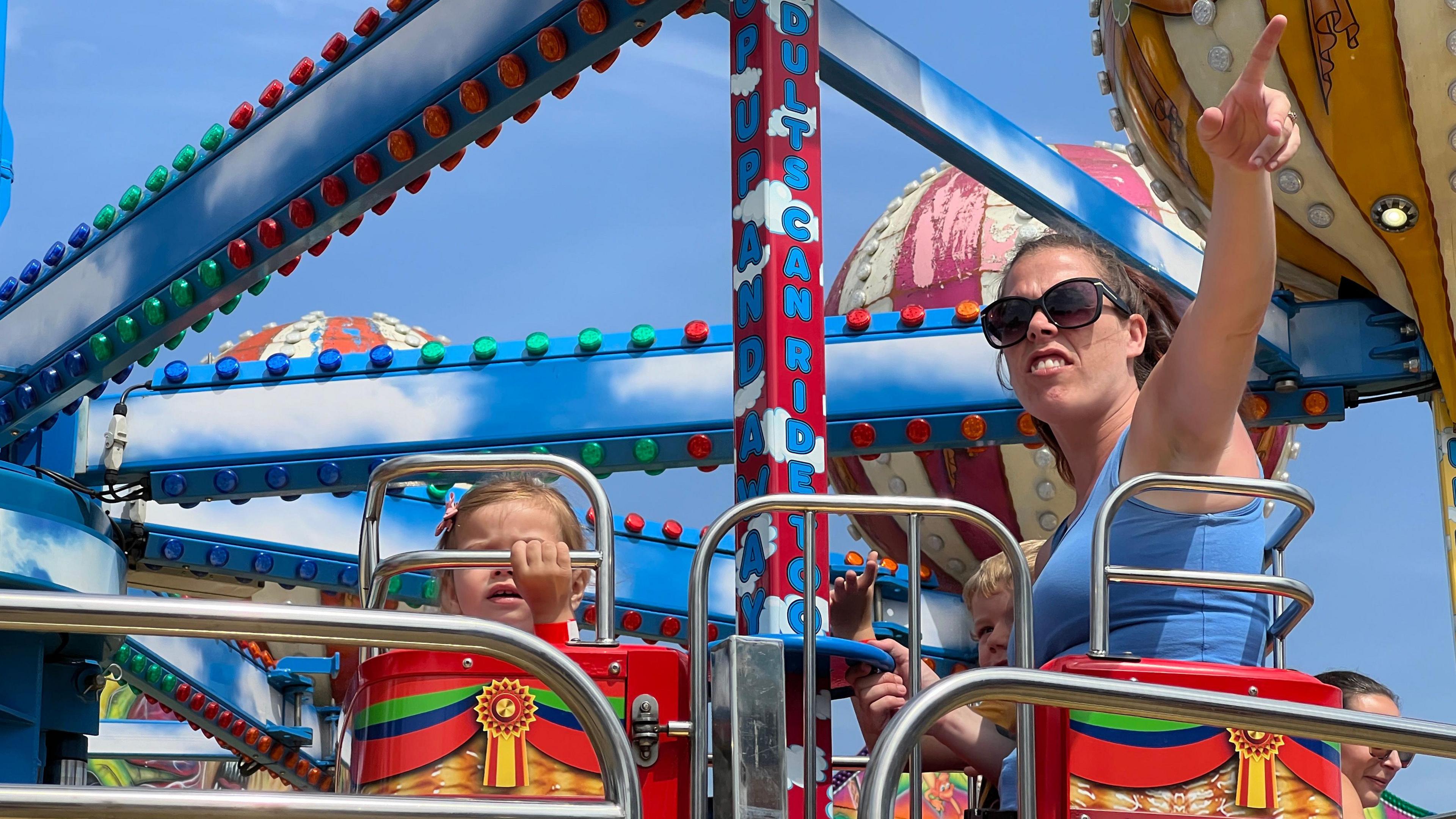 A mother and her children enjoy a ride as she points to the distance