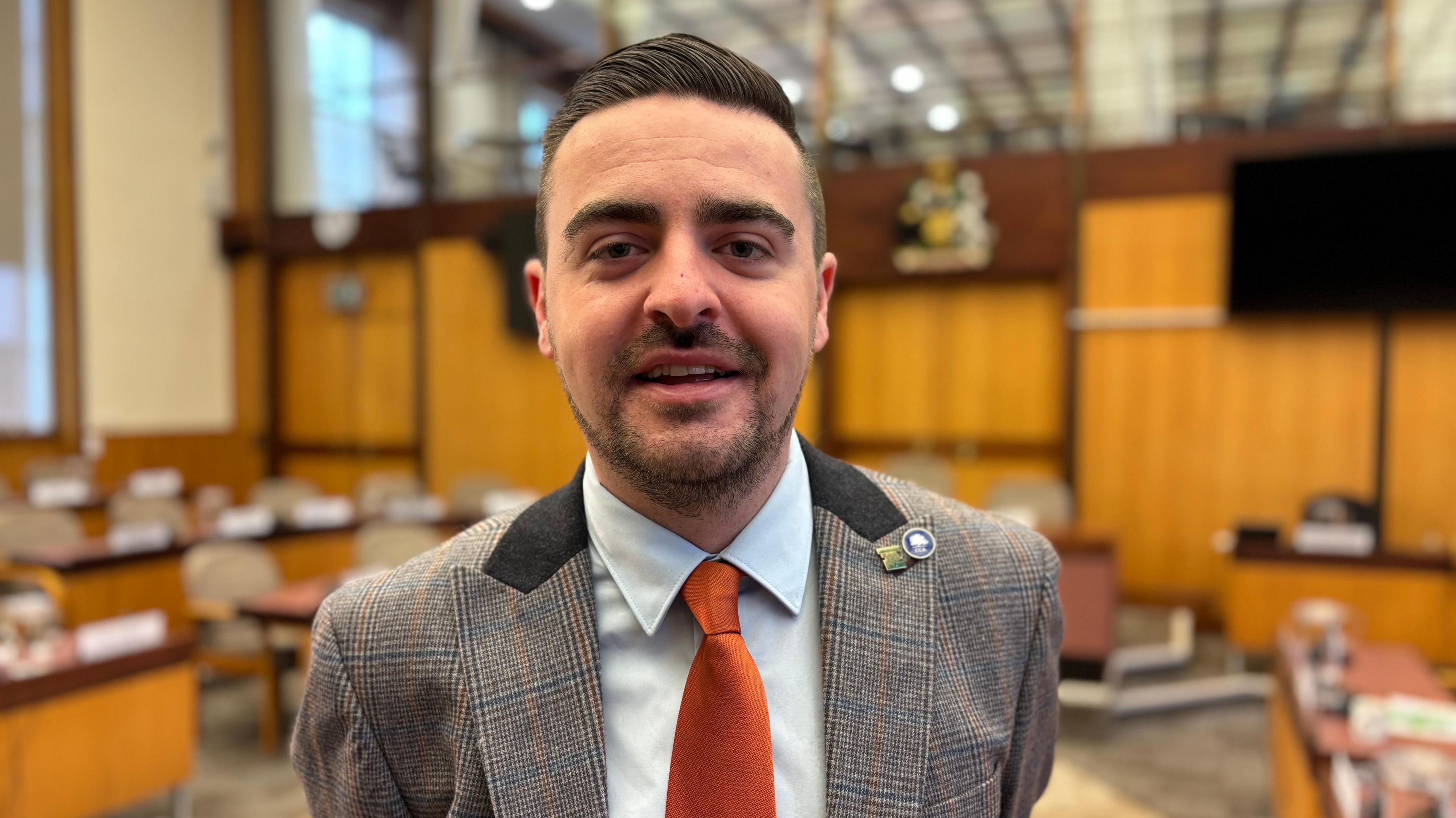 New Nottinghamshire County Council leader Sam Smith is pictured with a powder blue shirt, orange tie and a blazer.