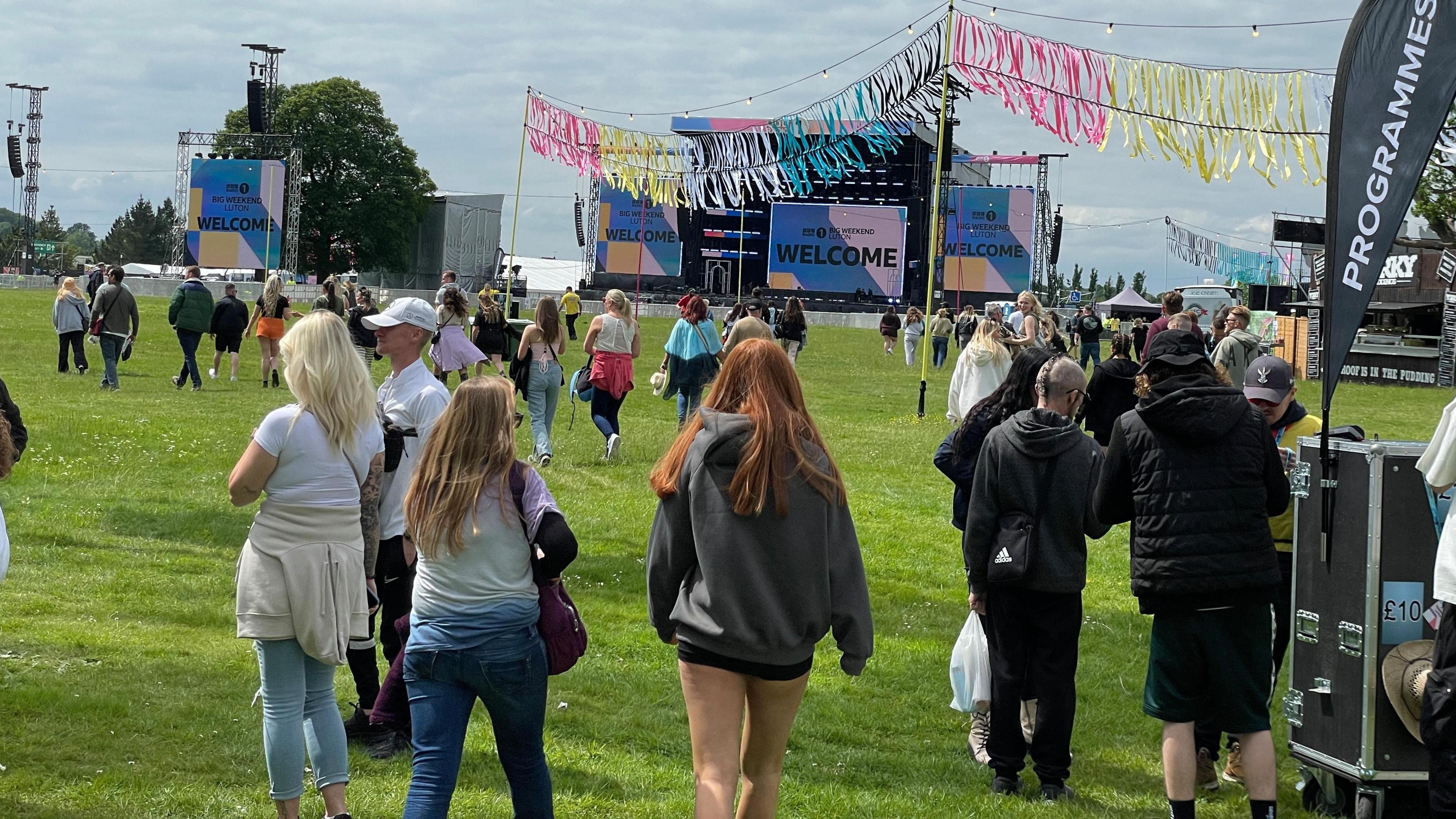 The backs of crowds walking into Radio 1's Big Weekend