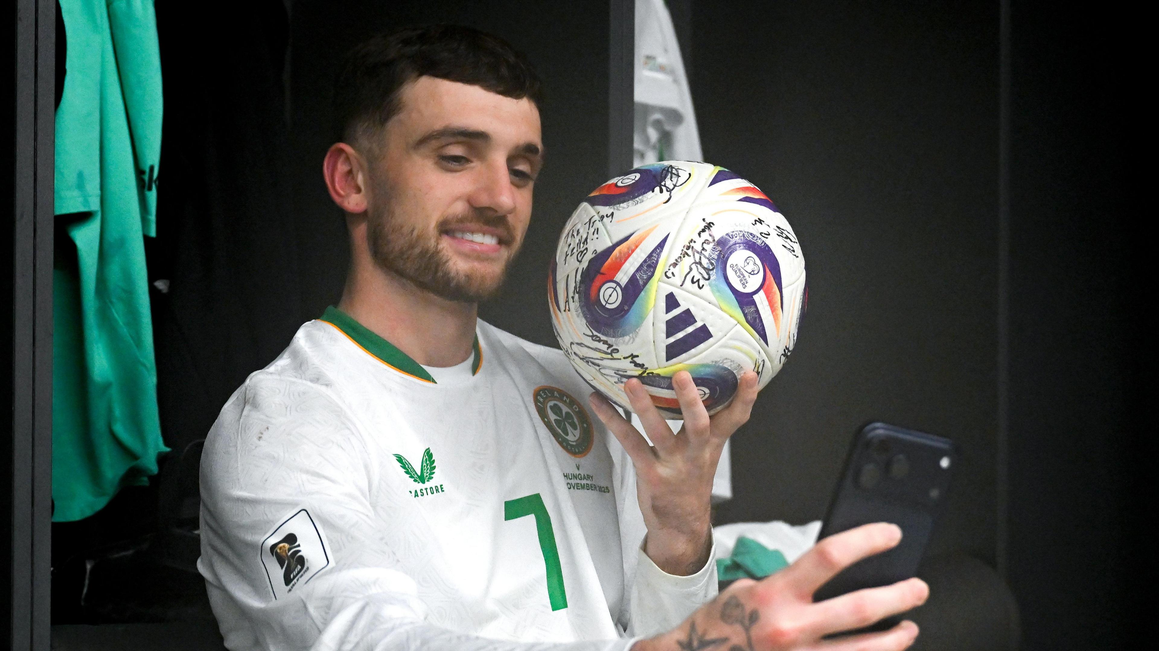 Troy Parrott poses with the match ball after his hat-trick against Hungary in Budapest