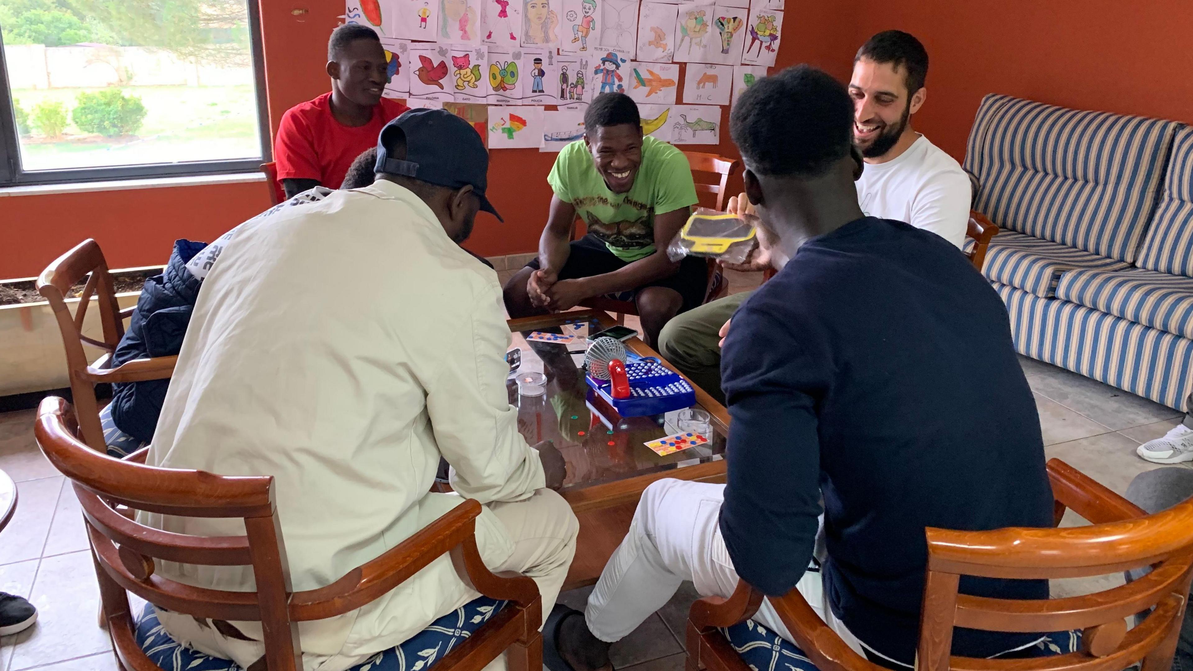 Smiling asylum seekers playing the game bingo at a hotel in northern Spain