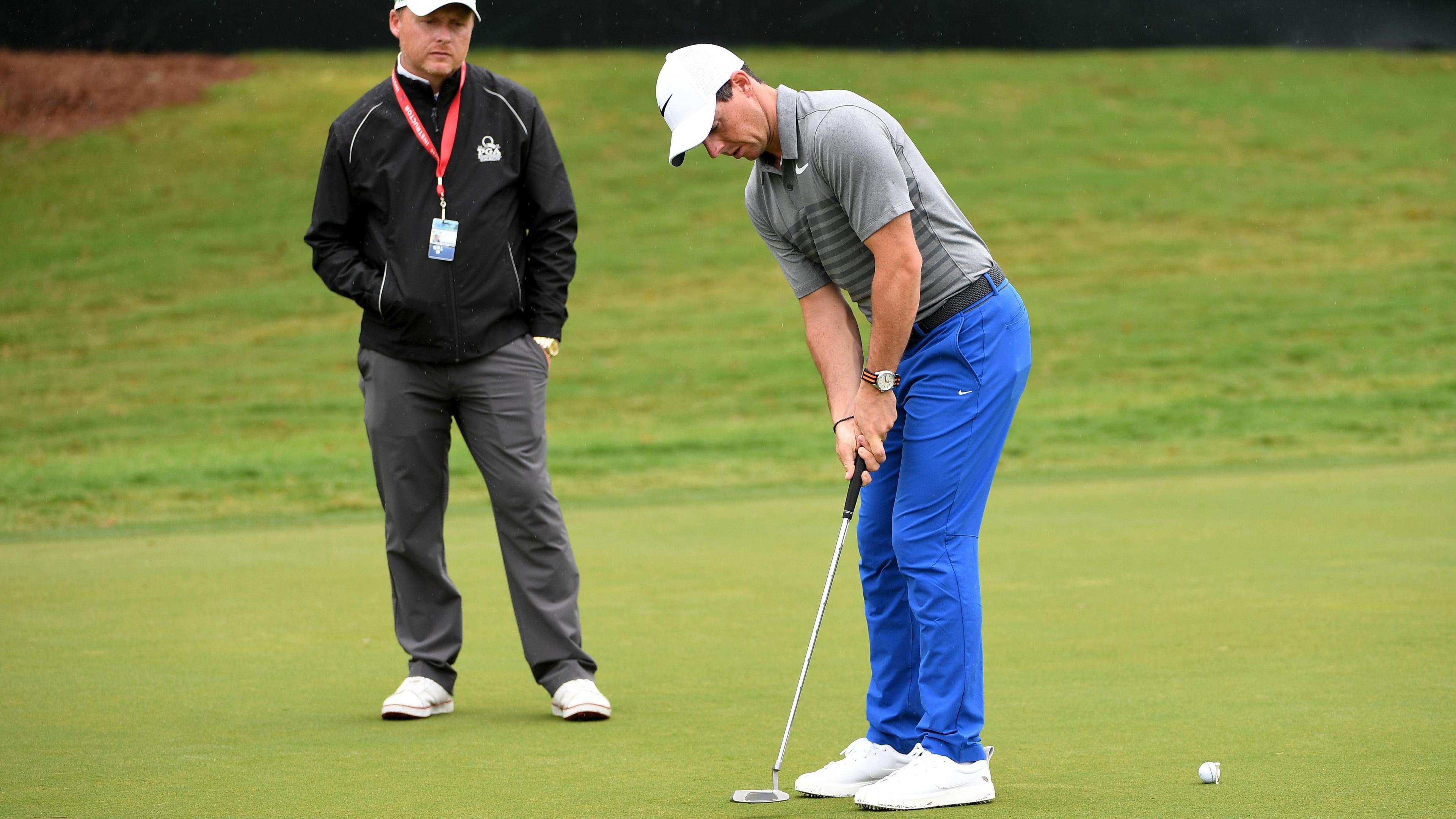 Phil Kenyon watches Rory McIlroy hit a putt during practice