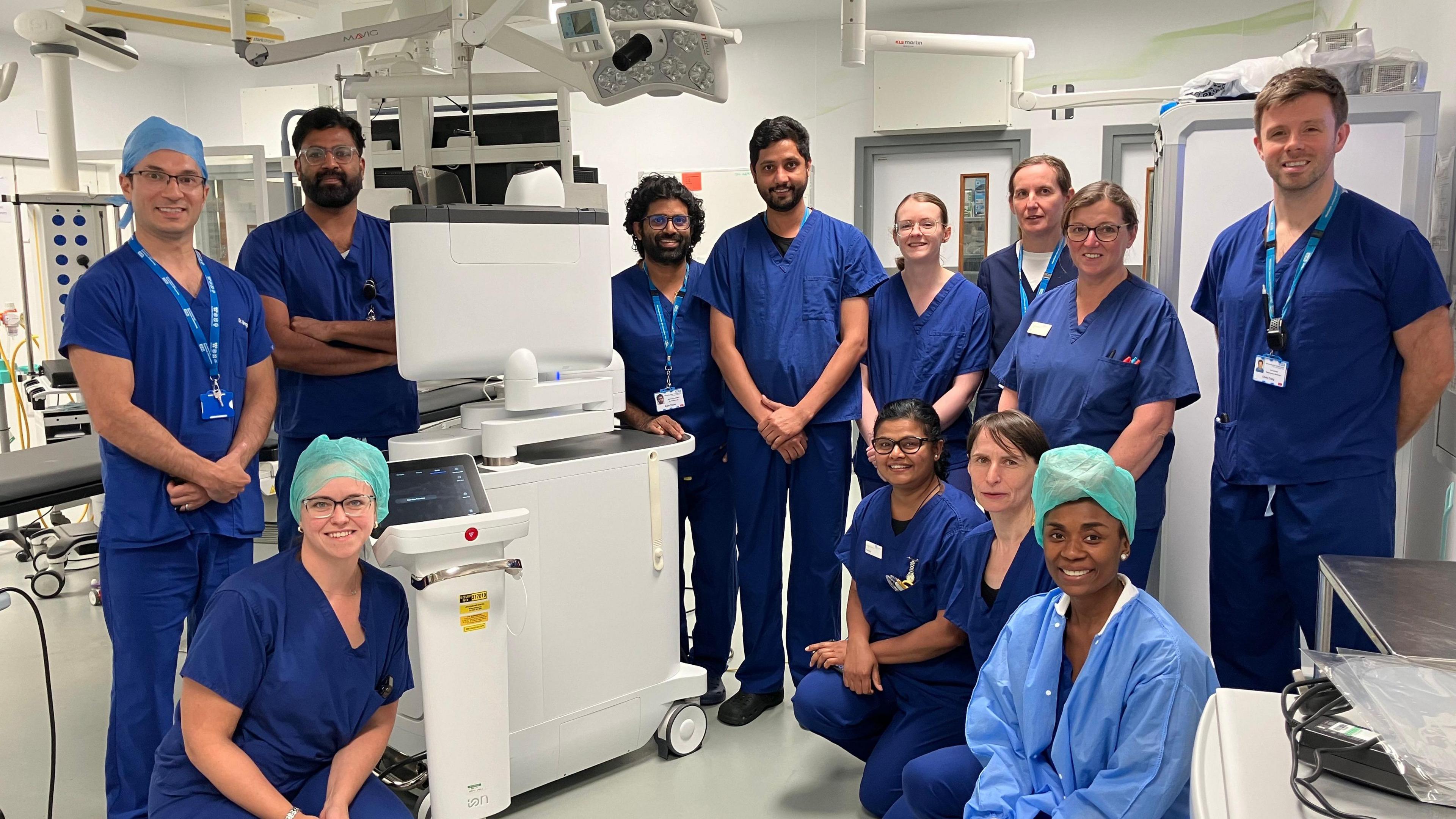 Healthcare staff at Wythenshawe Hospital wearing blue scrubs stood around the new Ion probe technology