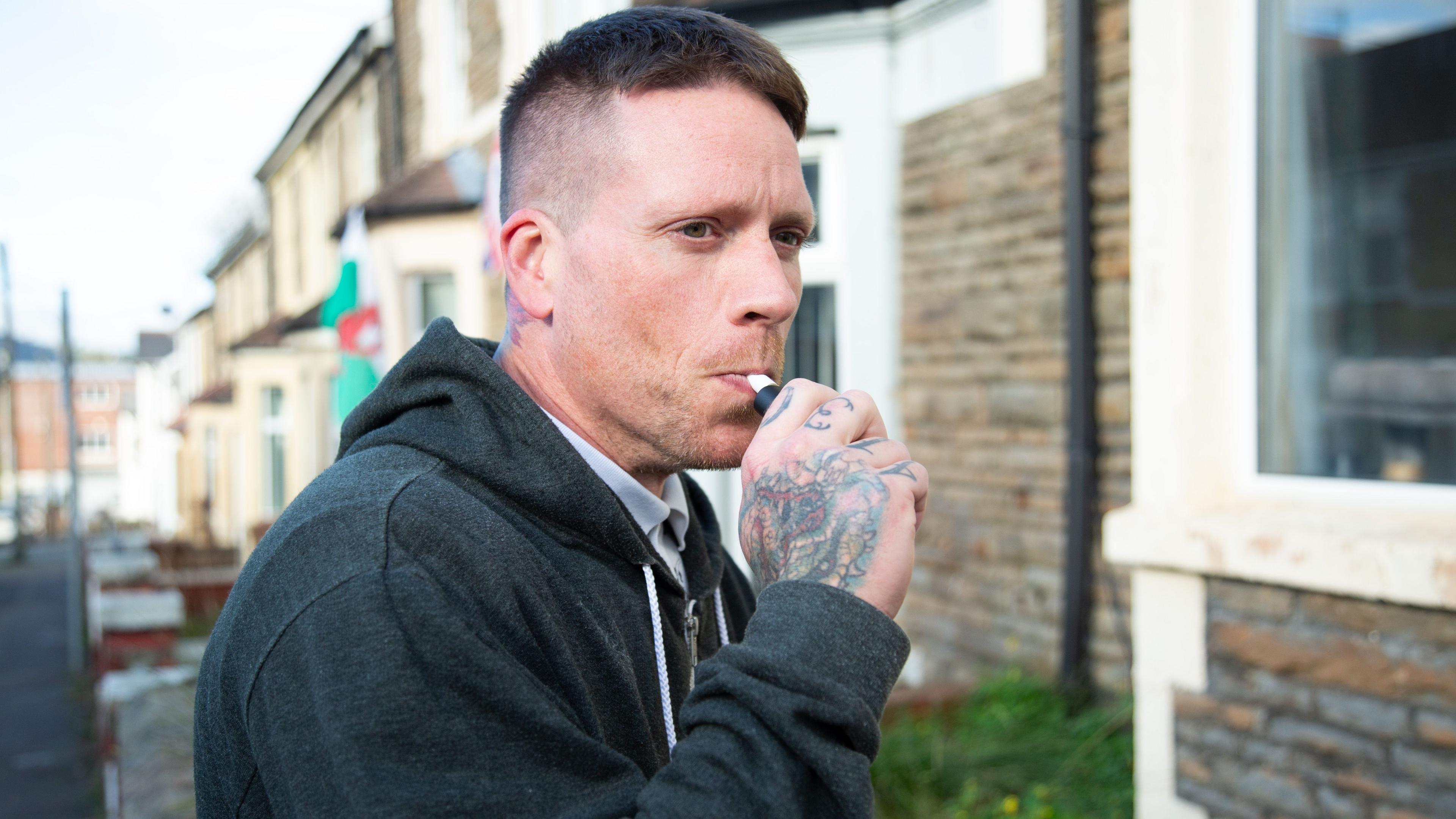 Dyn ar stryd yn cymryd fêp