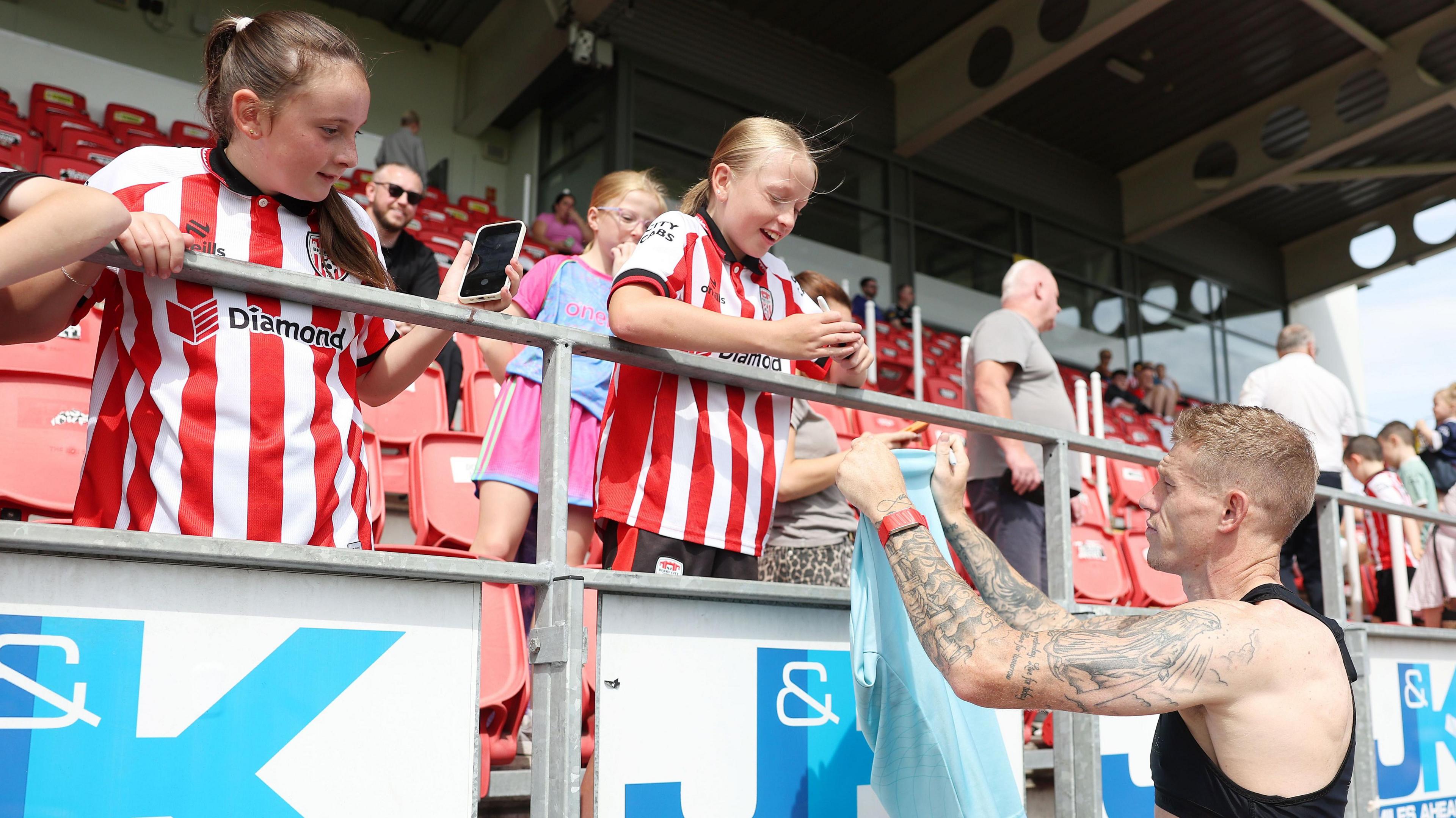 James McClean hands his Derry City training top to a young fan