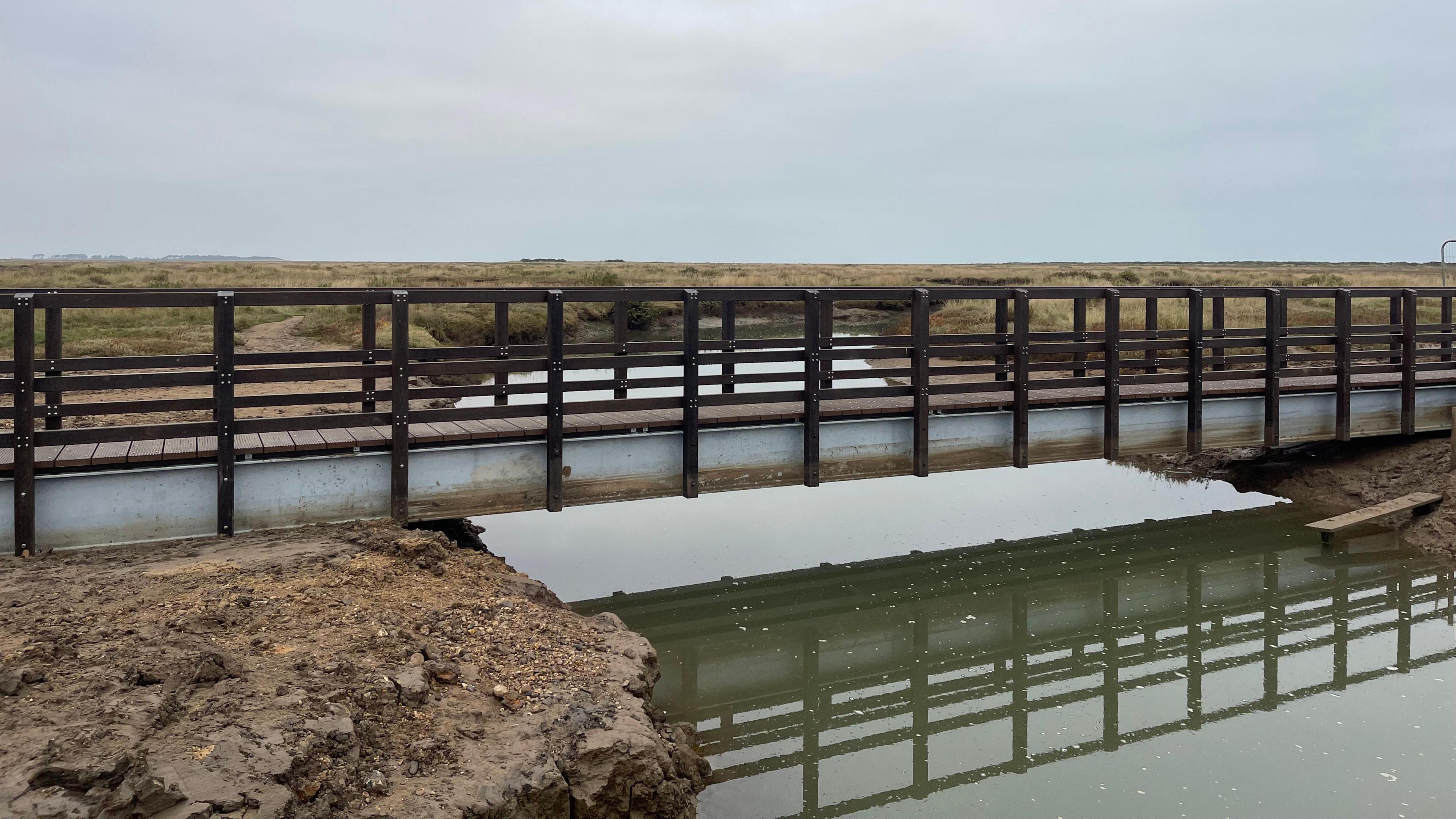 A view of the new Stiffkey bridge over a creek.