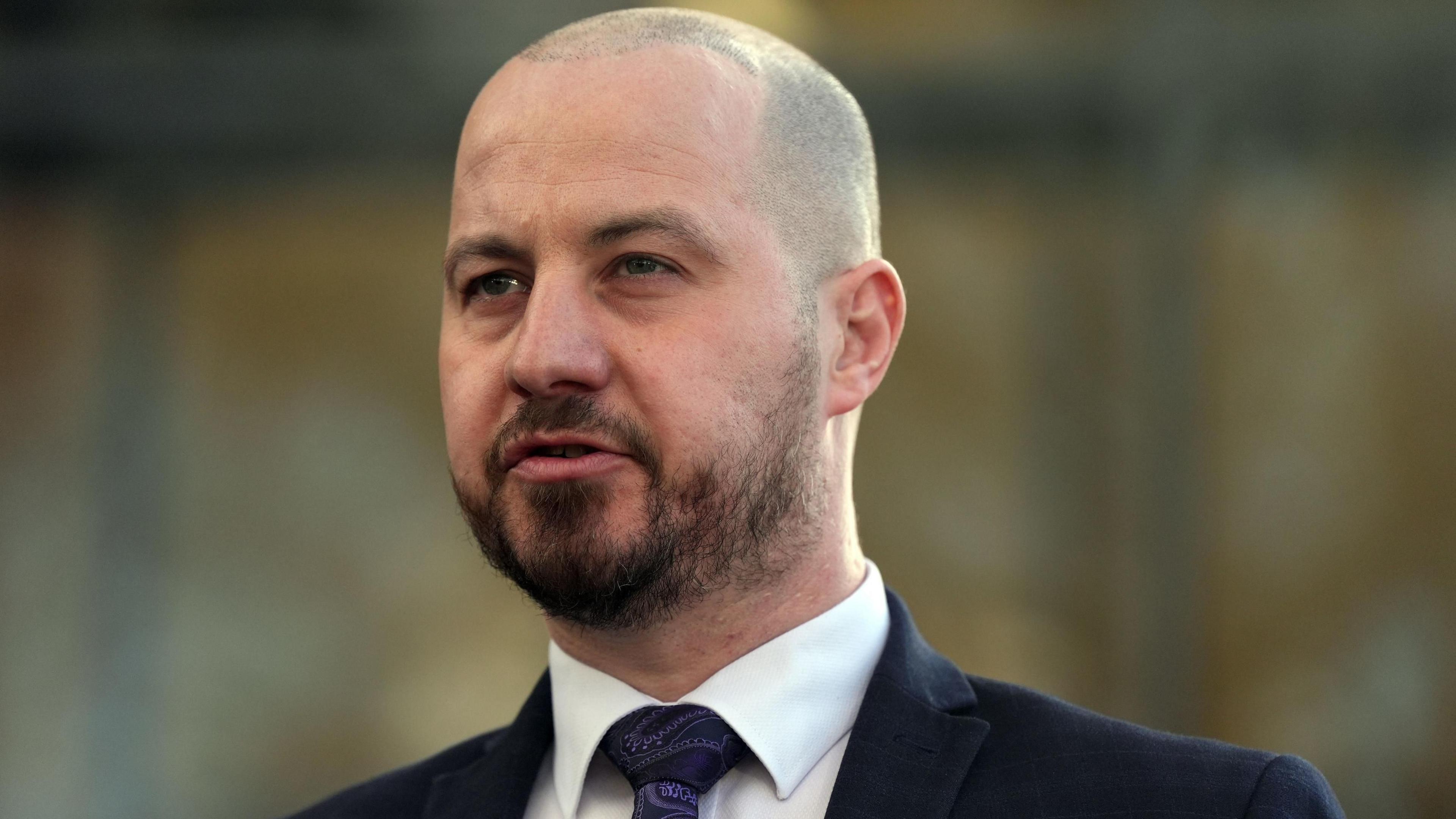 Detective chief inspector Nick Gardner speaking outside Cambridge Crown Court. He has a shaven head, a dark beard and is wearing a suit.