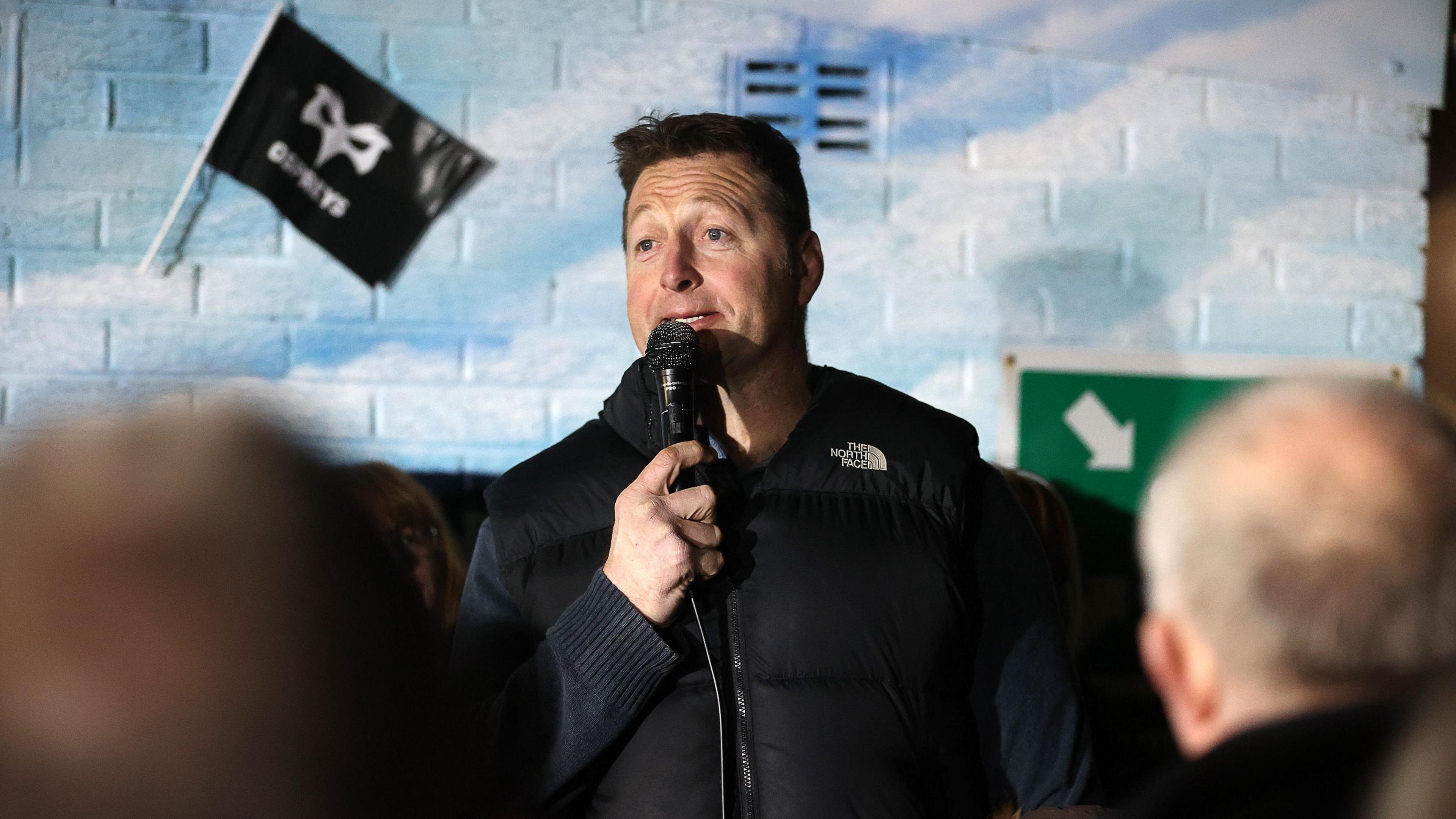 Ian Gough, who is a former Ospreys and Wales lock, with the microphone in his hand