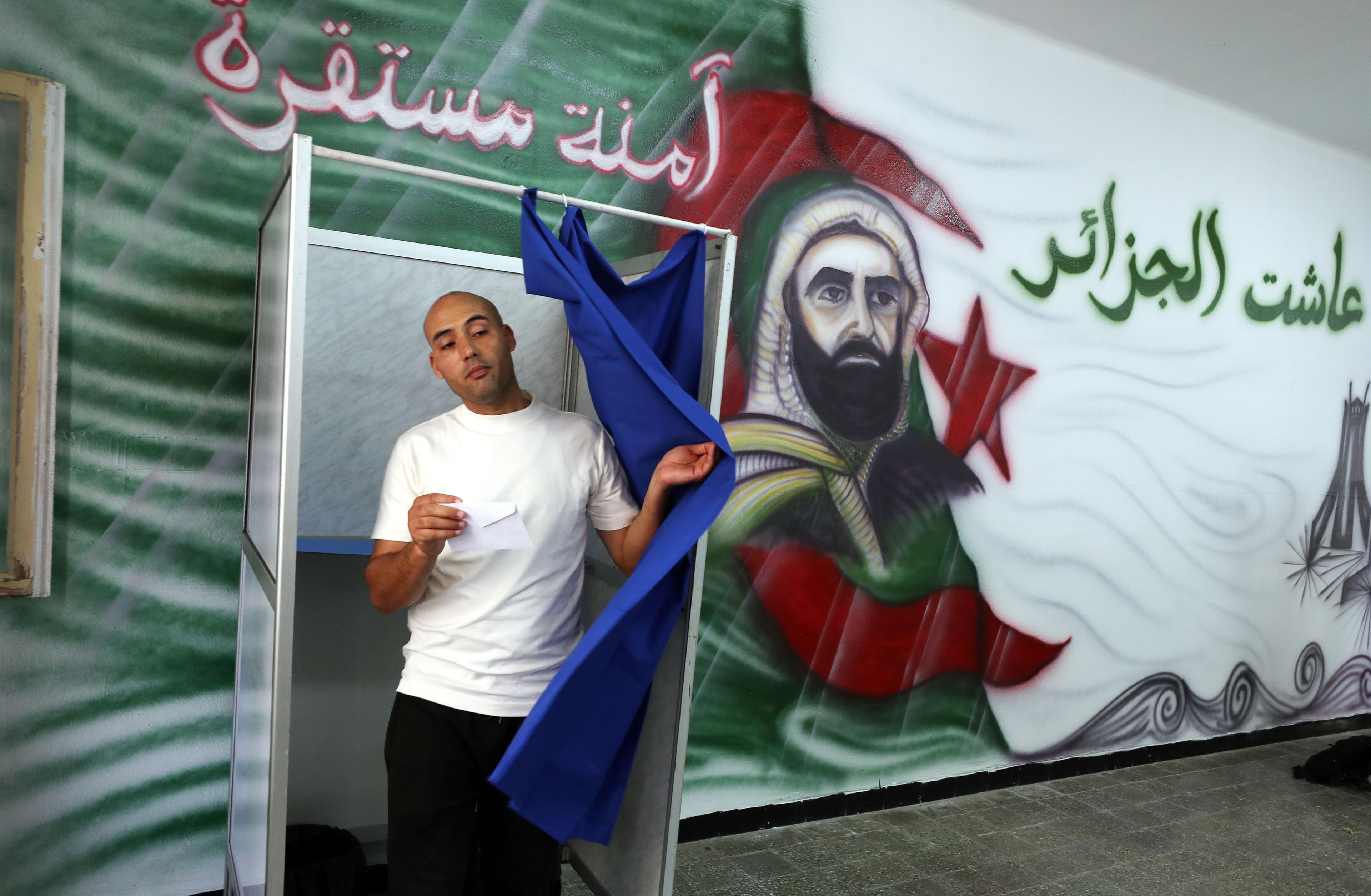 A voter exits a booth at a polling station during the presidential election in Algiers, Algeria.