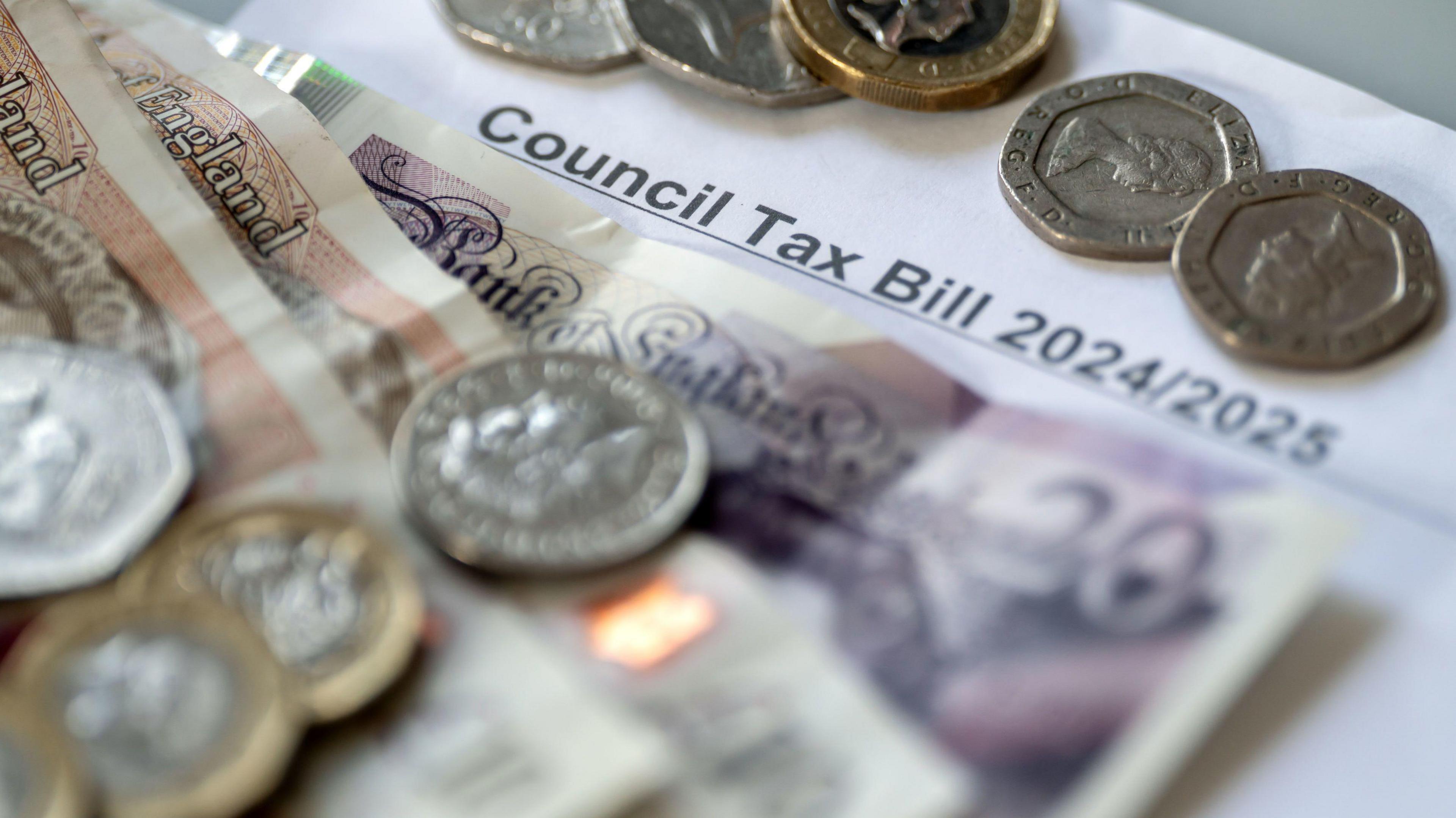 Generic image of a council tax bill with cash and coins spread over the top