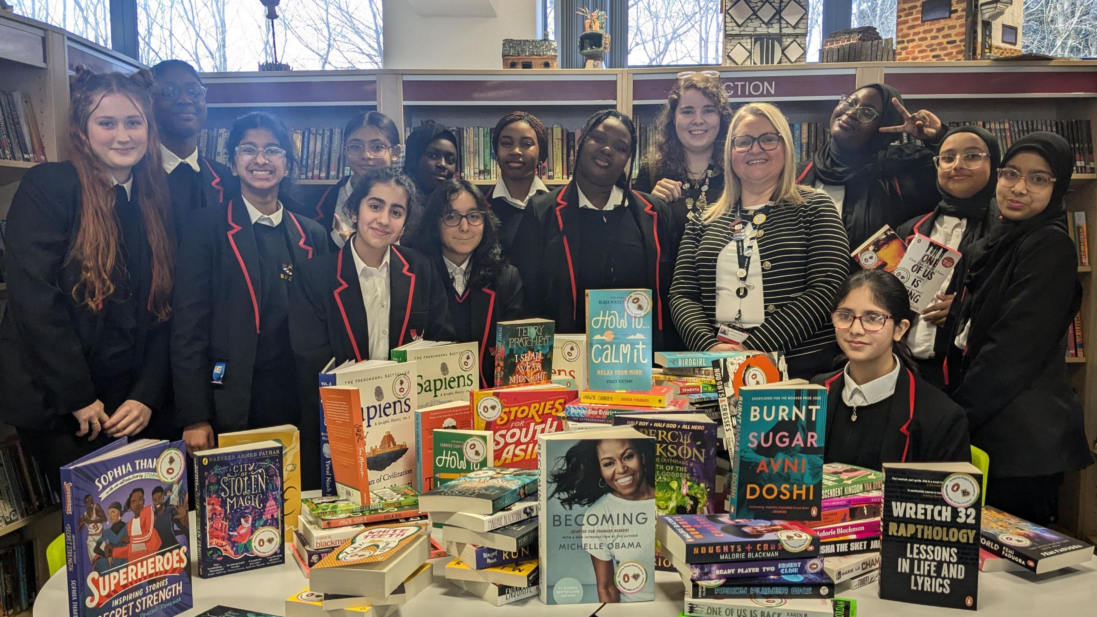 A group of students from the school standing with the donated books. 