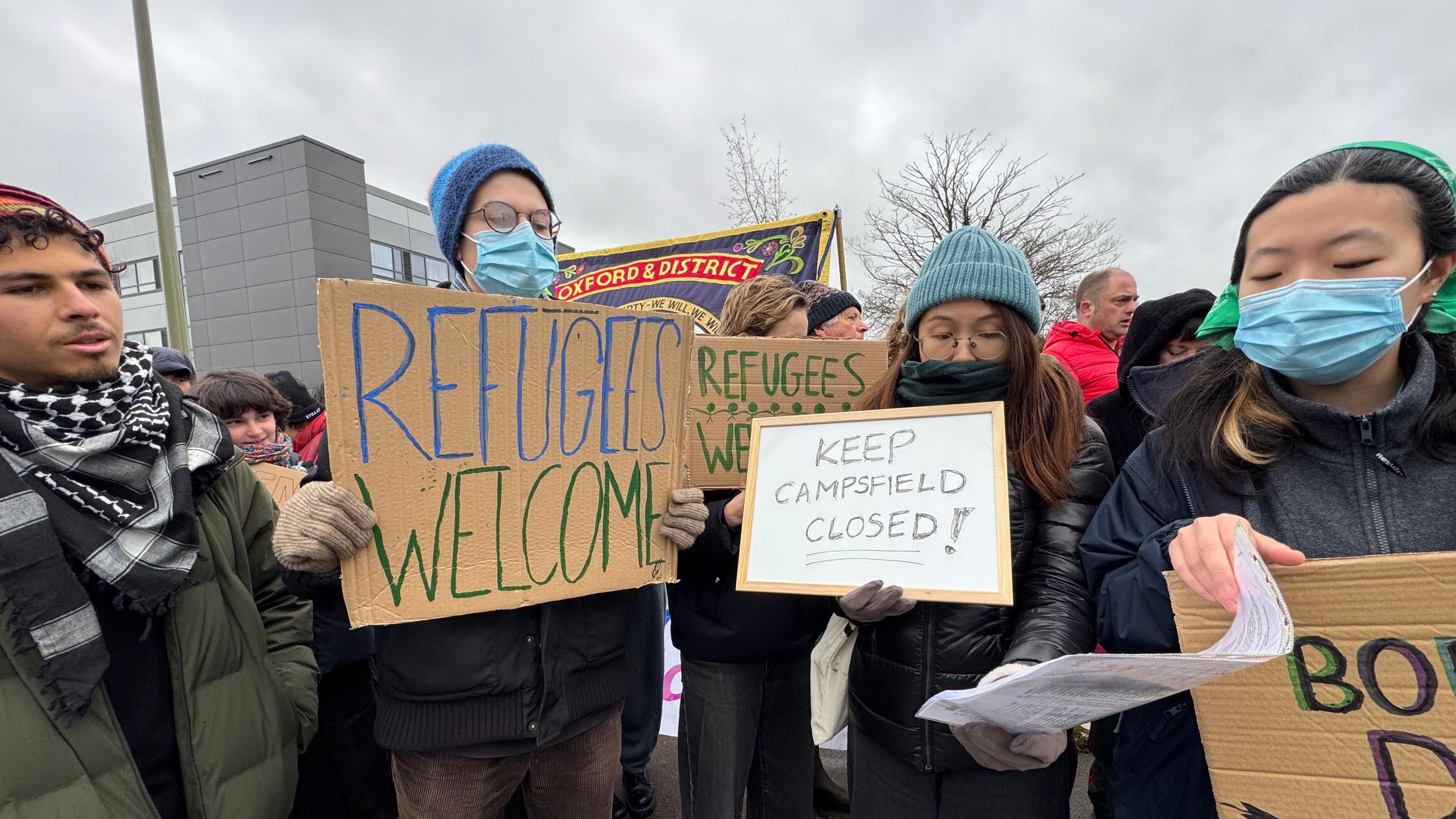 People hold placards saying "refugees welcome" and "keep Campsfield closed"