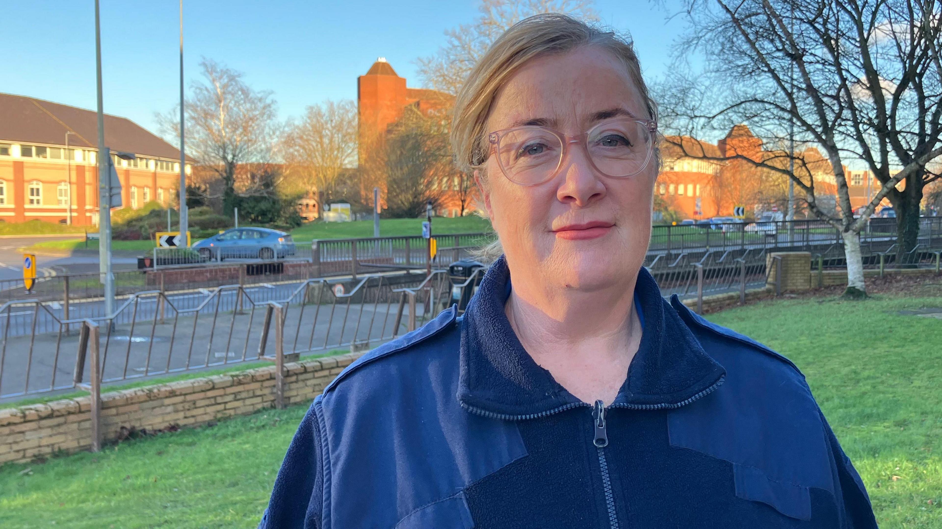 A head and shoulders picture of Tanya McGrath from the North Essex Parking Partnership outside her offices with a road and cars in the background