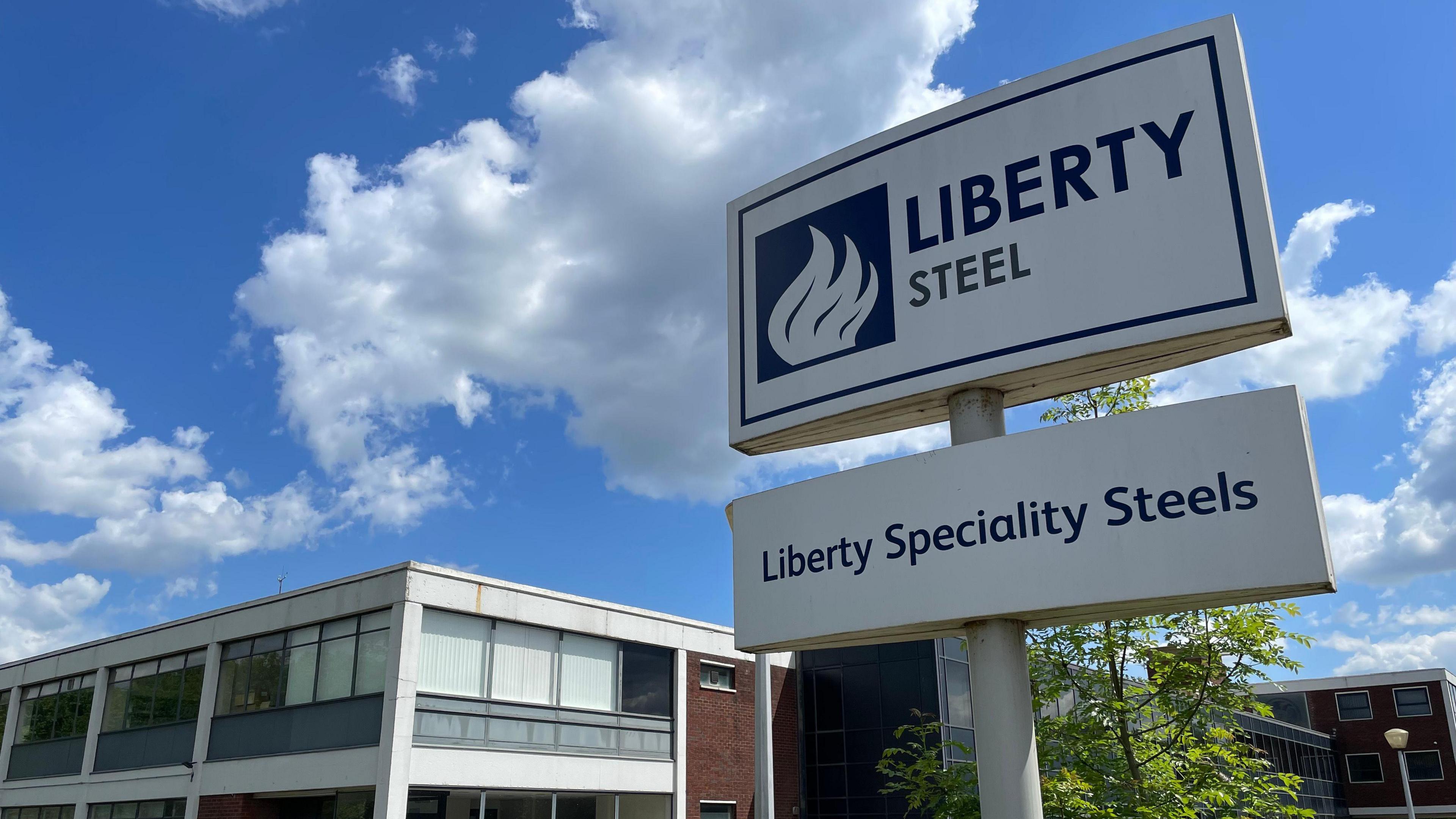 A sign advertising Liberty Steel outside a building.