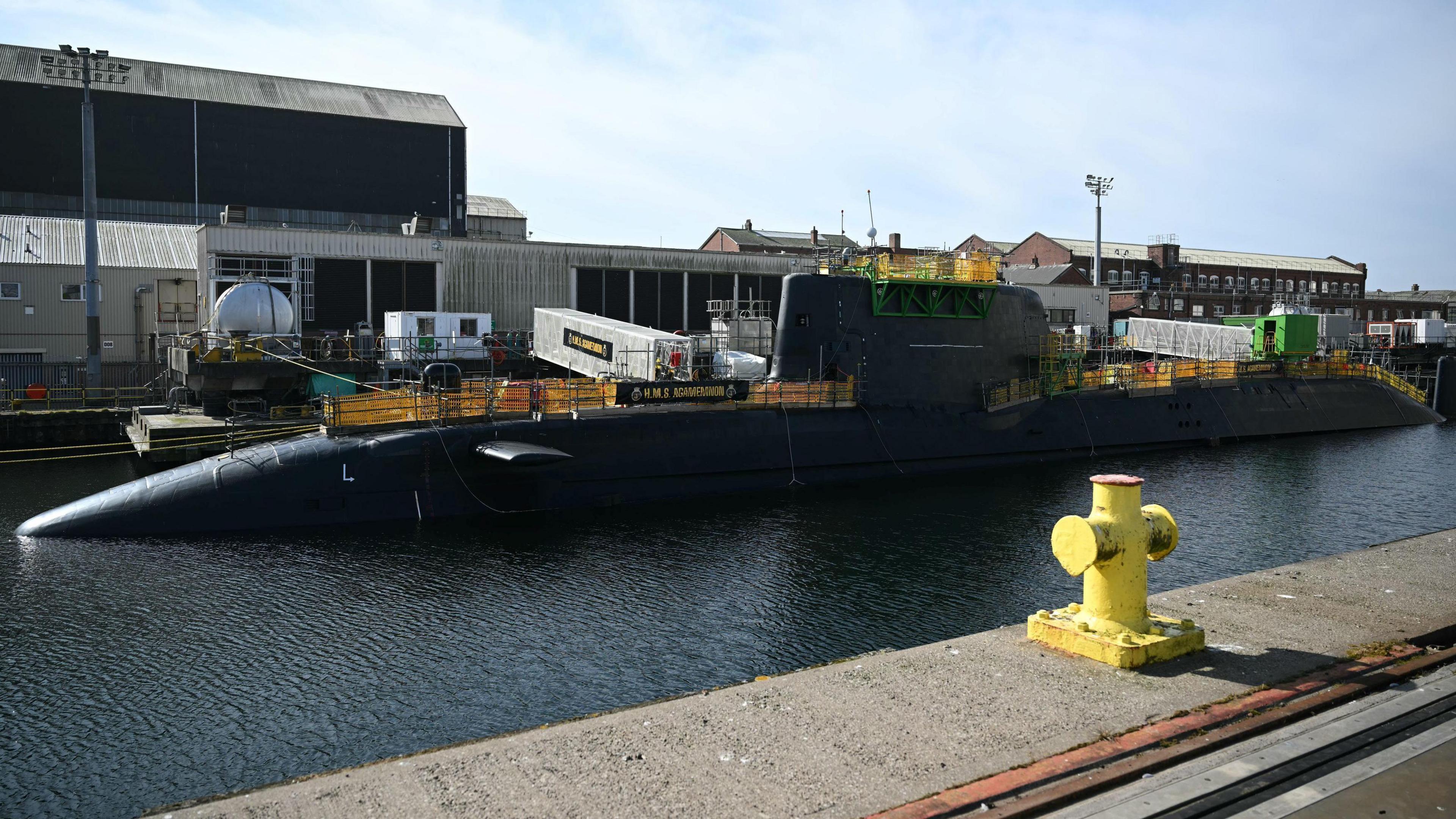 HMS Agamemnon nuclear submarine at the BAE Systems factory, Barrow-in-Furness, Cumbria. There is an industrial port on the other side of the water, which has the submarine in it. 