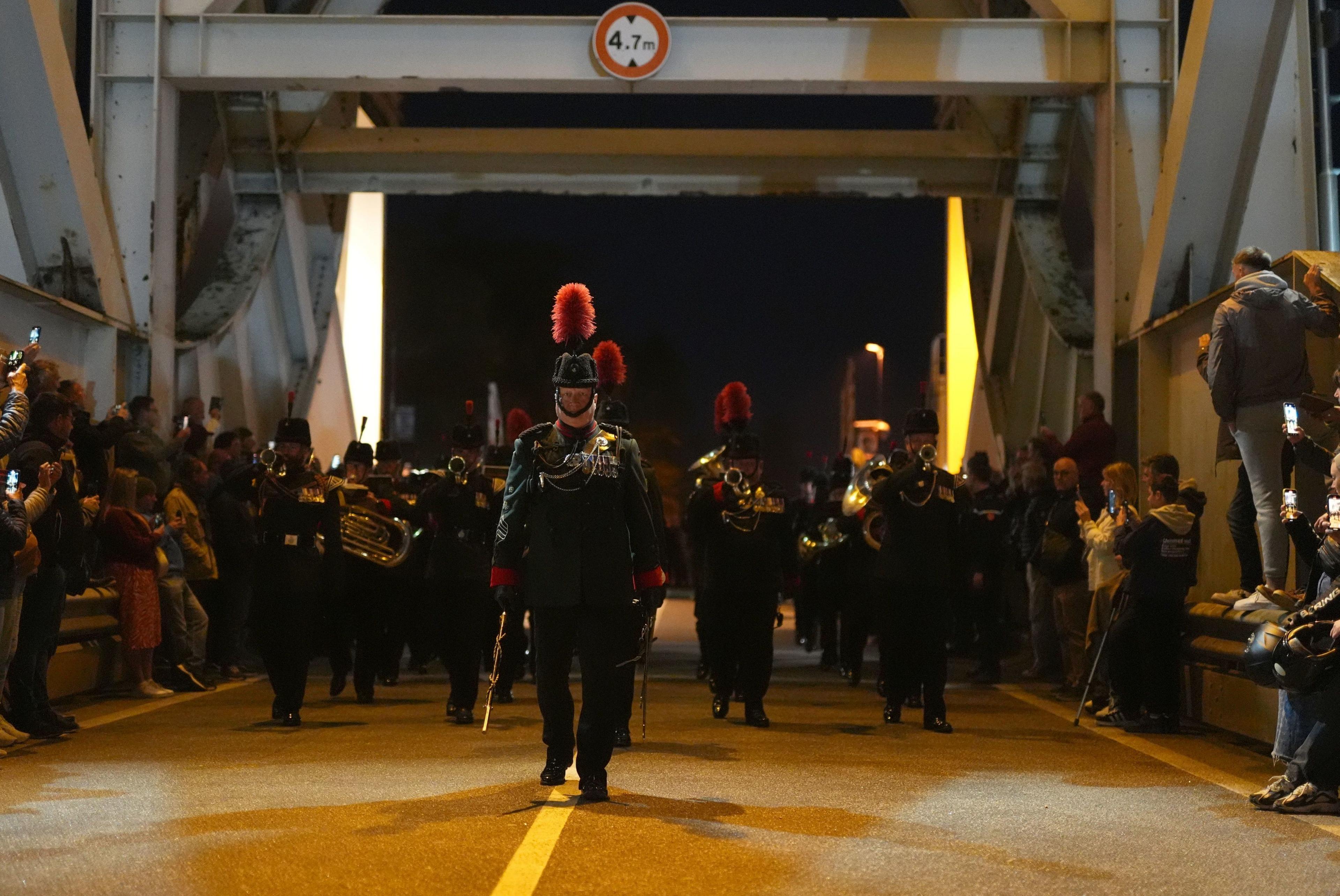 Serving paratroopers from the Parachute Regiment, the Rifles, the Army Air Corps and the Salamanca Band and Bugles of the Rifles, march at the double across Pegasus Bridge