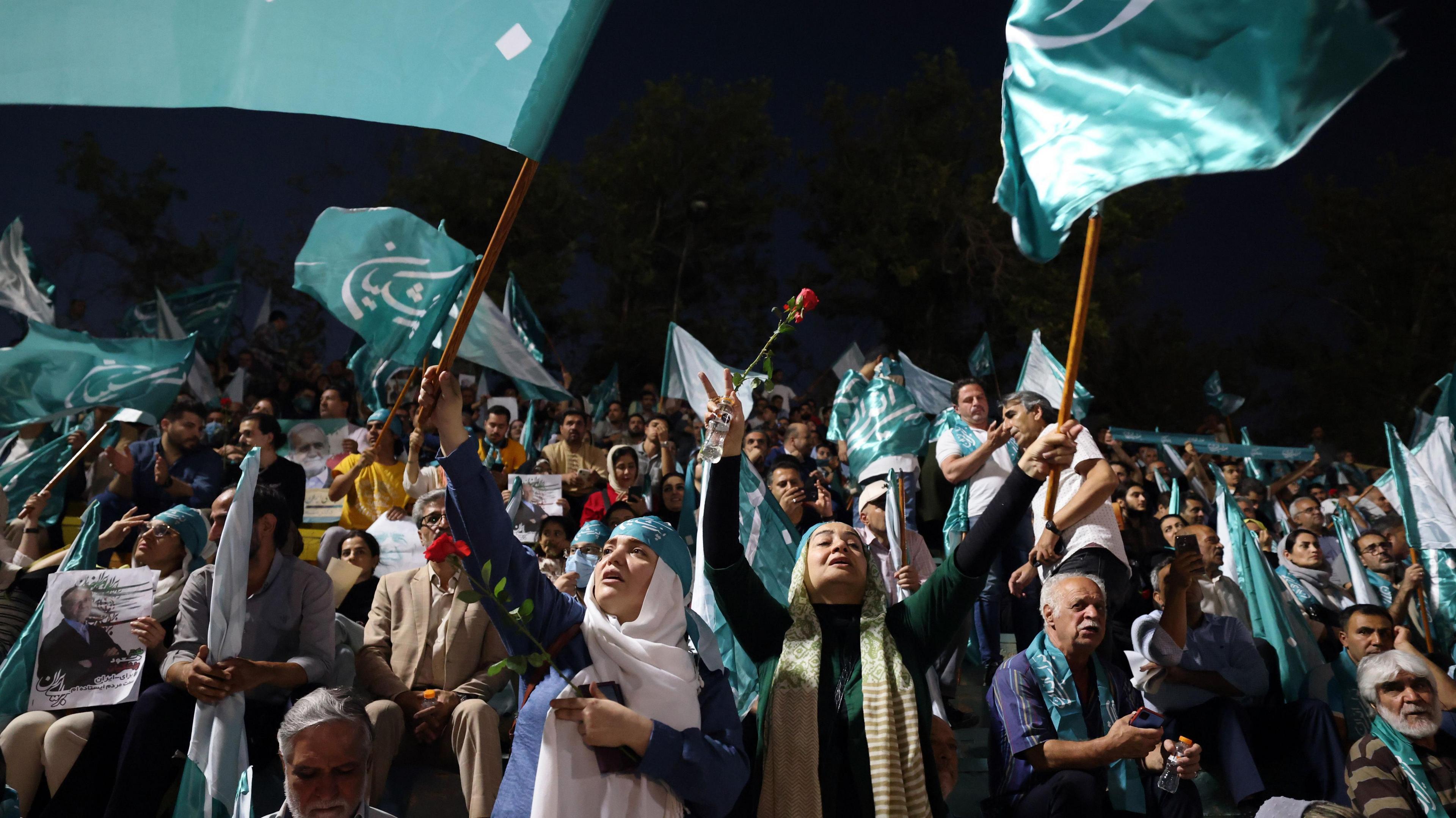 Female supporters of Masoud Pezeshkian wave green flags bearing his name at a rally in Tehran, Iran (5 July 2024)