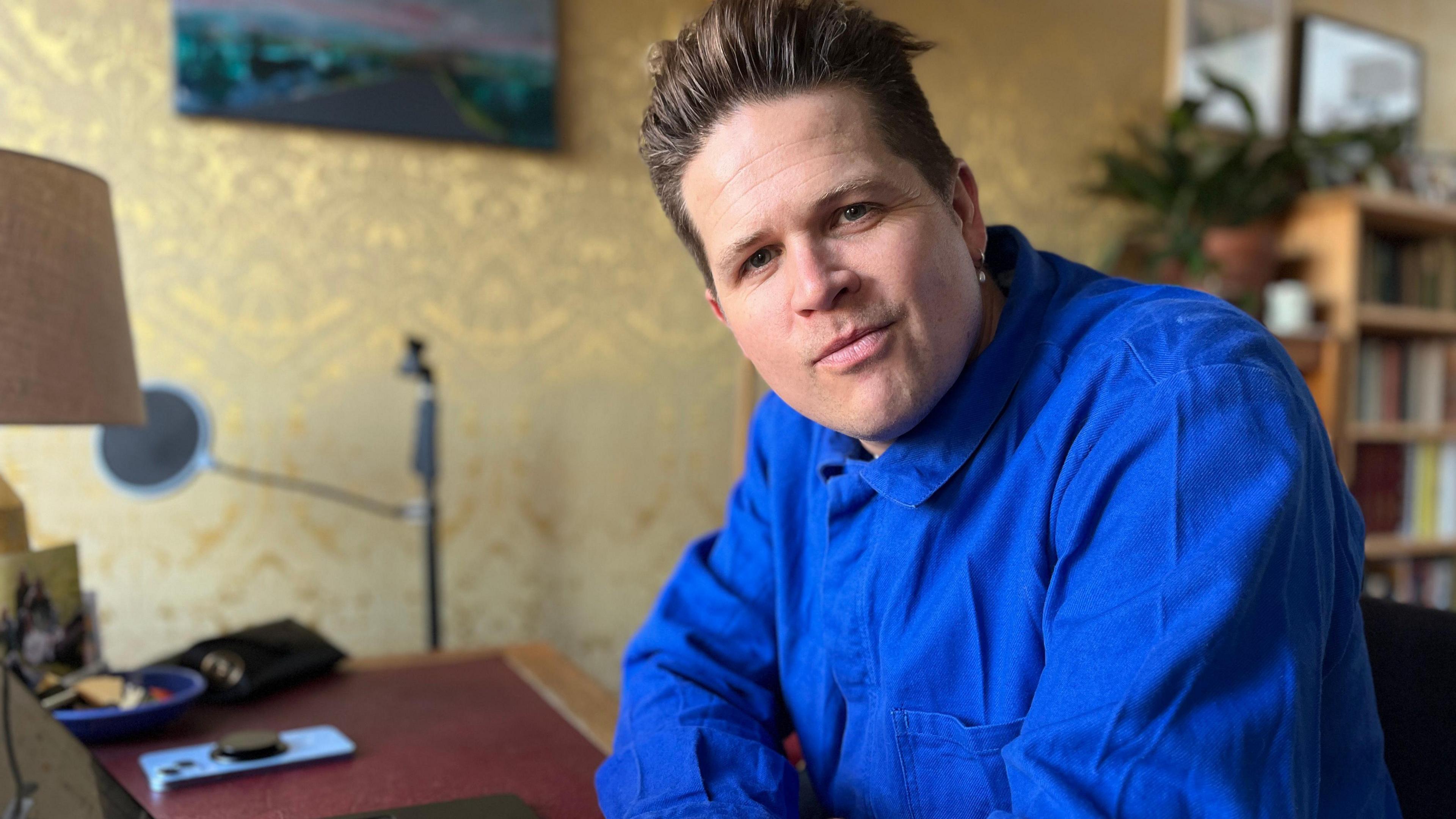 Poet Luke Wright smiling from a desk.